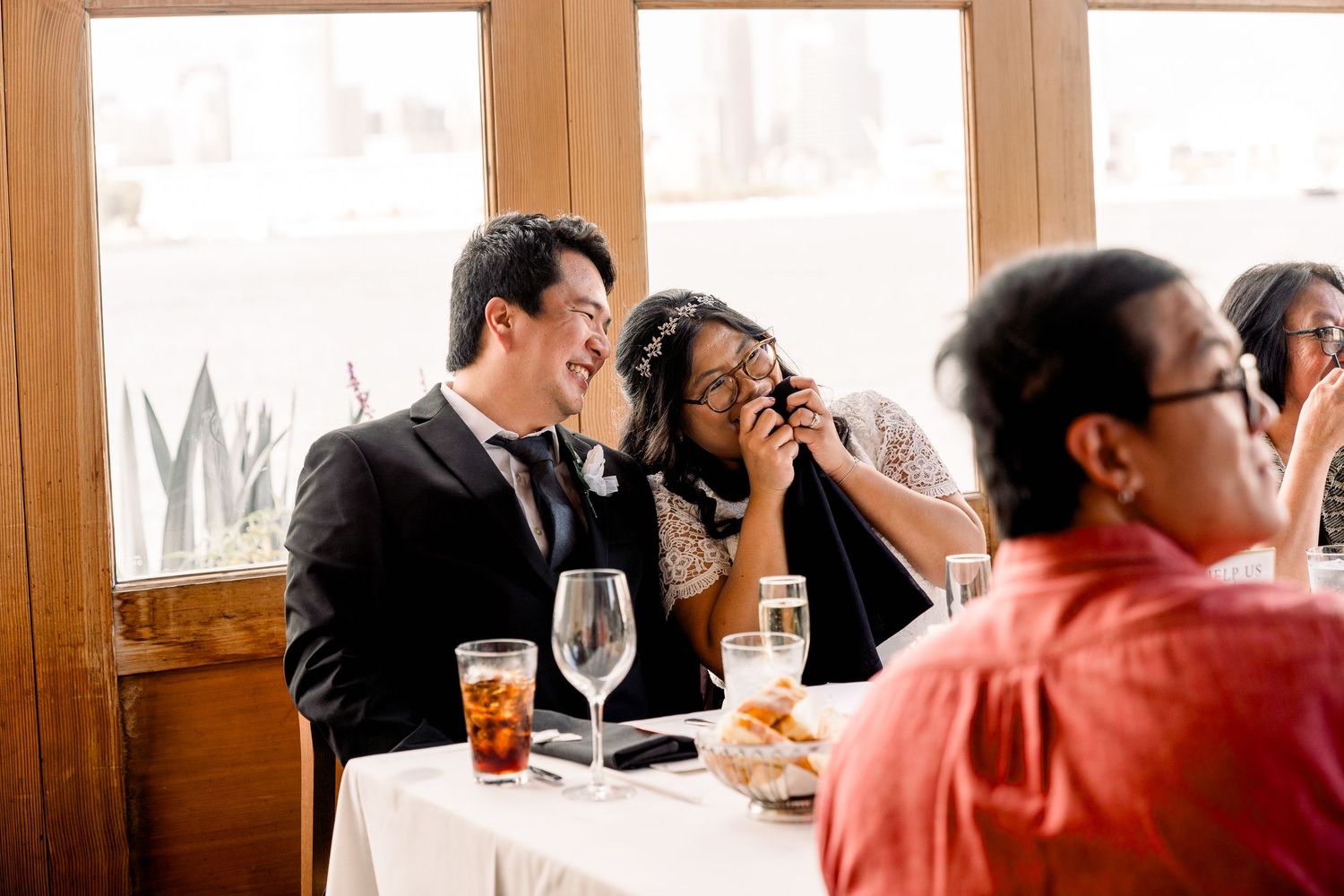 Wedding reception guests enjoying drinks and conversation at an elegant indoor venue.