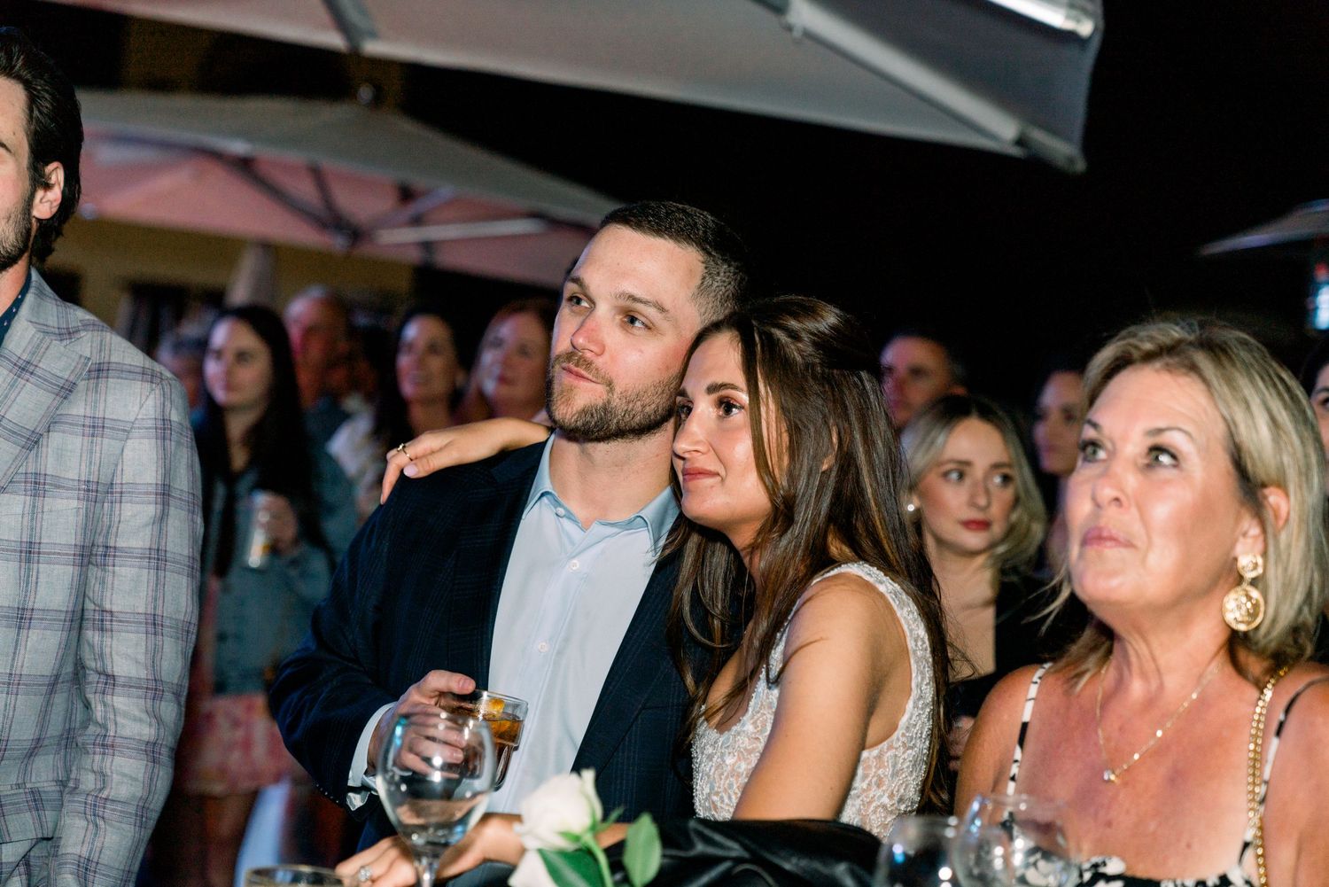 Guests attentively watch a presentation during an elegant evening gathering.