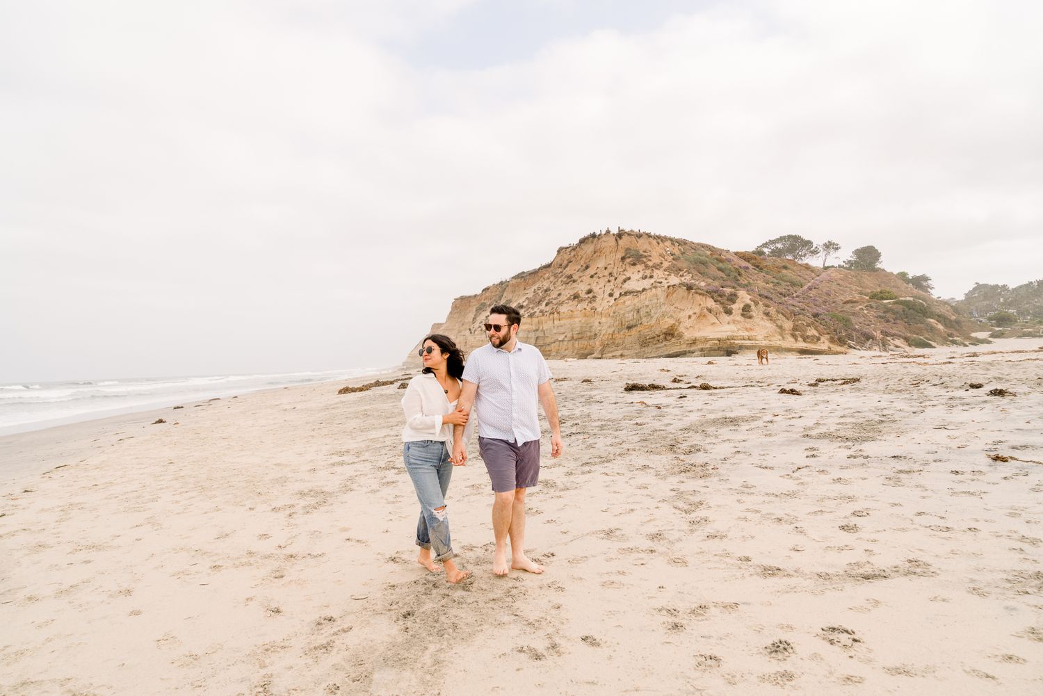 Romantic beach engagement session for San Diego couples at Del Mar Dig Beach with Pup
