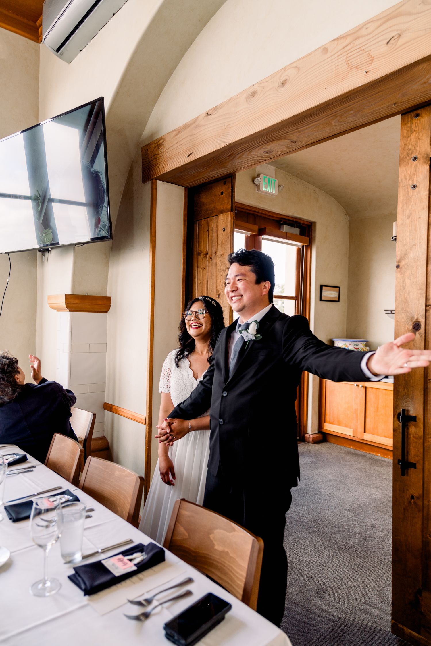 A joyful celebration moment in a rustic venue with wooden beam details.