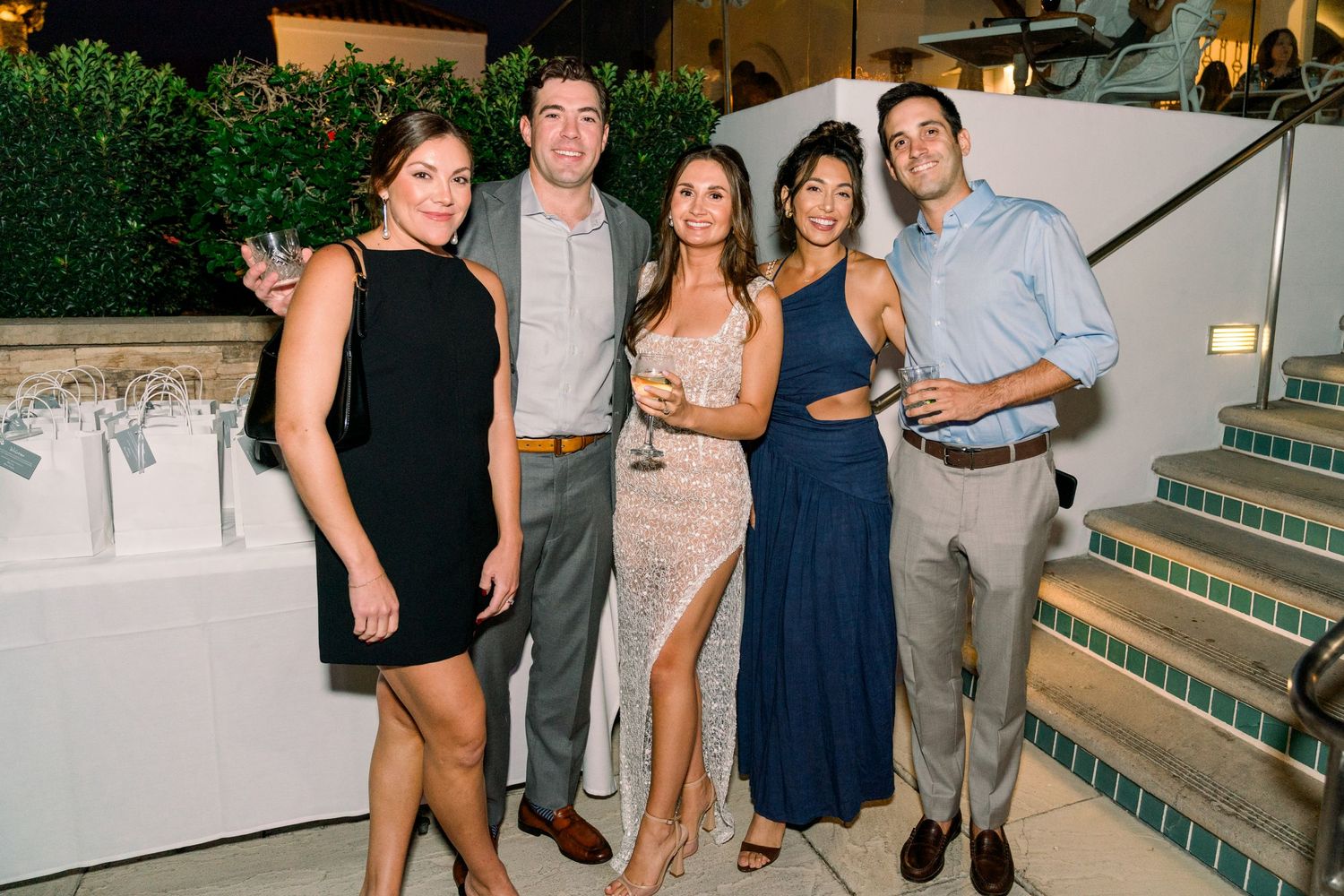 Group photo at an upscale outdoor evening event.