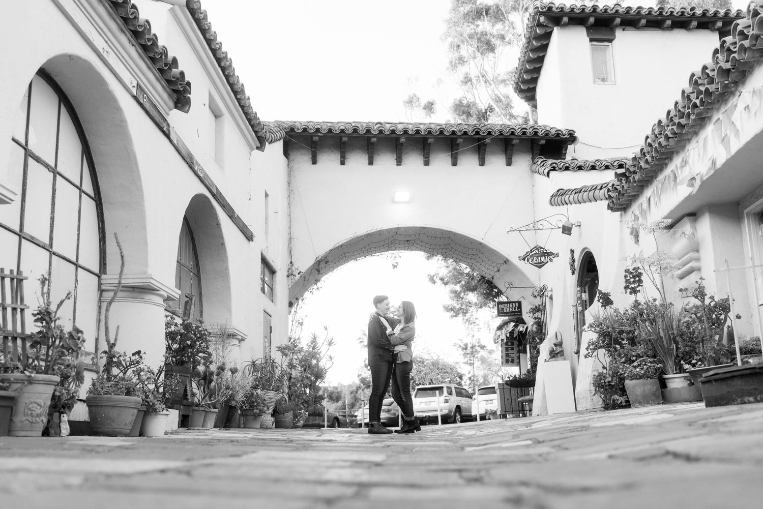 Black and white photo of people under Spanish-style archways in a courtyard.