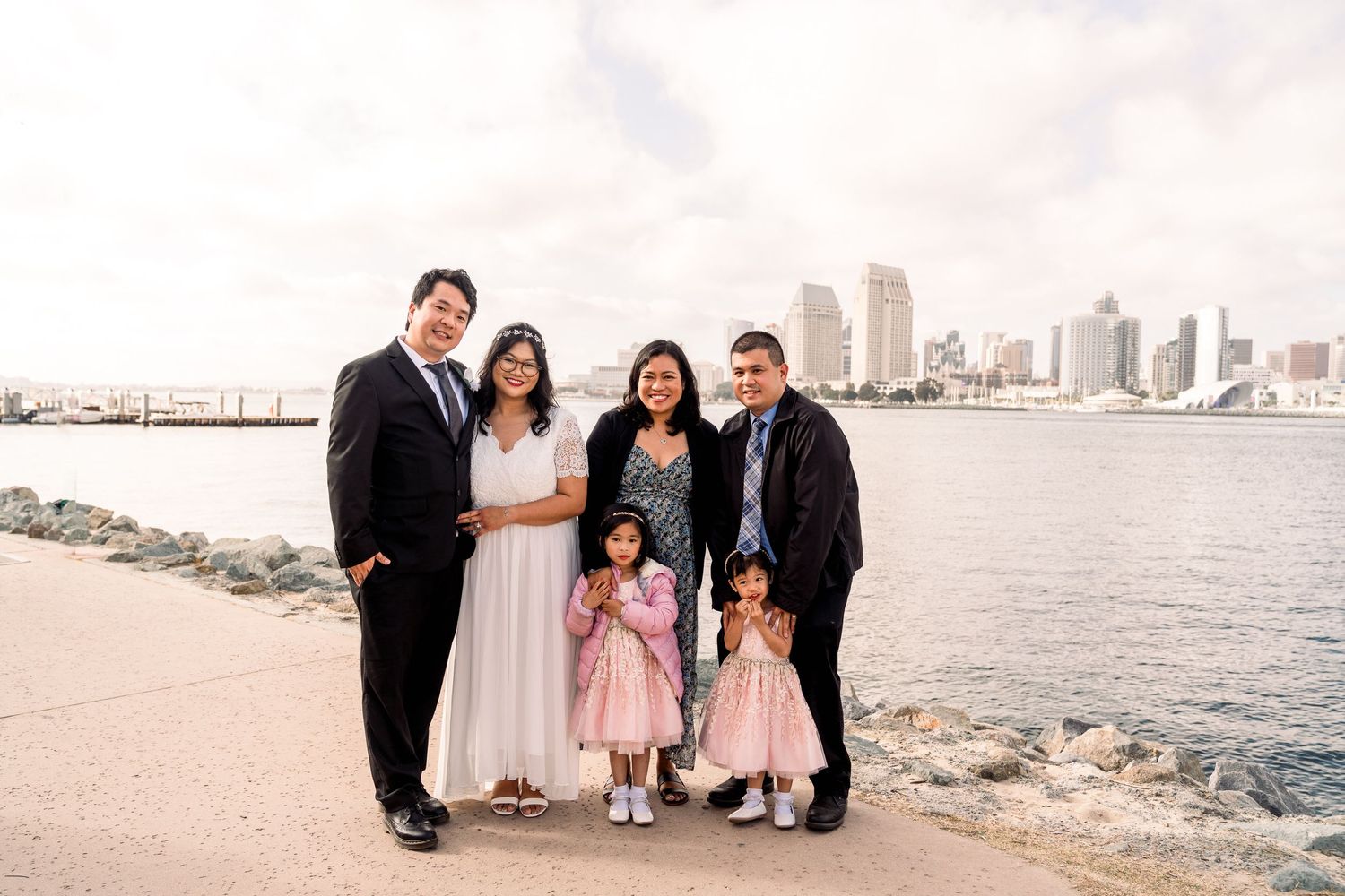 Family portrait with cityscape waterfront view of San Diego in the background.