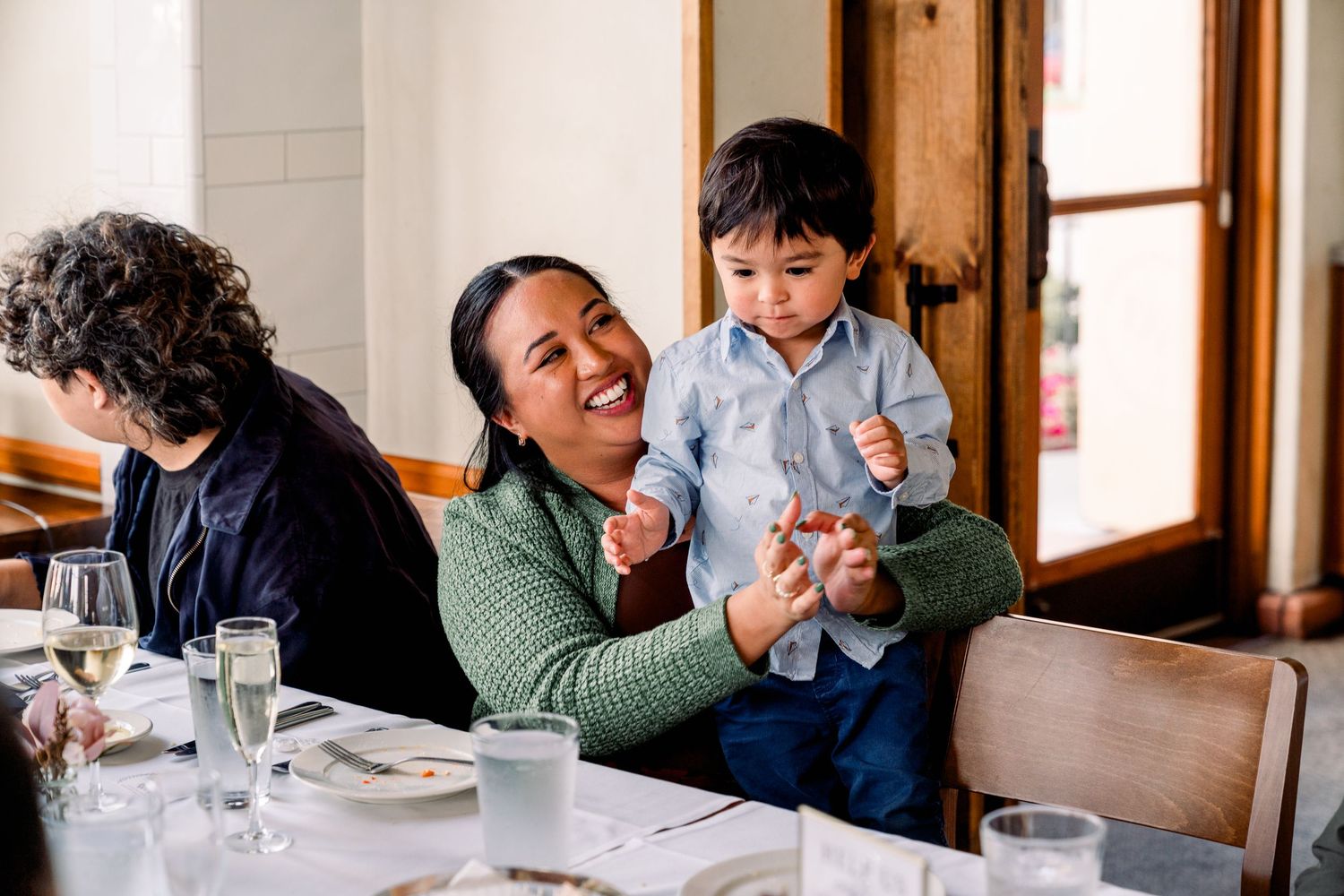 A joyful moment shared during a family dinner gathering in a rustic restaurant setting.