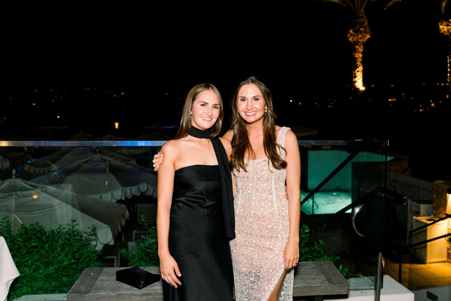 Elegant evening celebration on a rooftop venue with city lights.