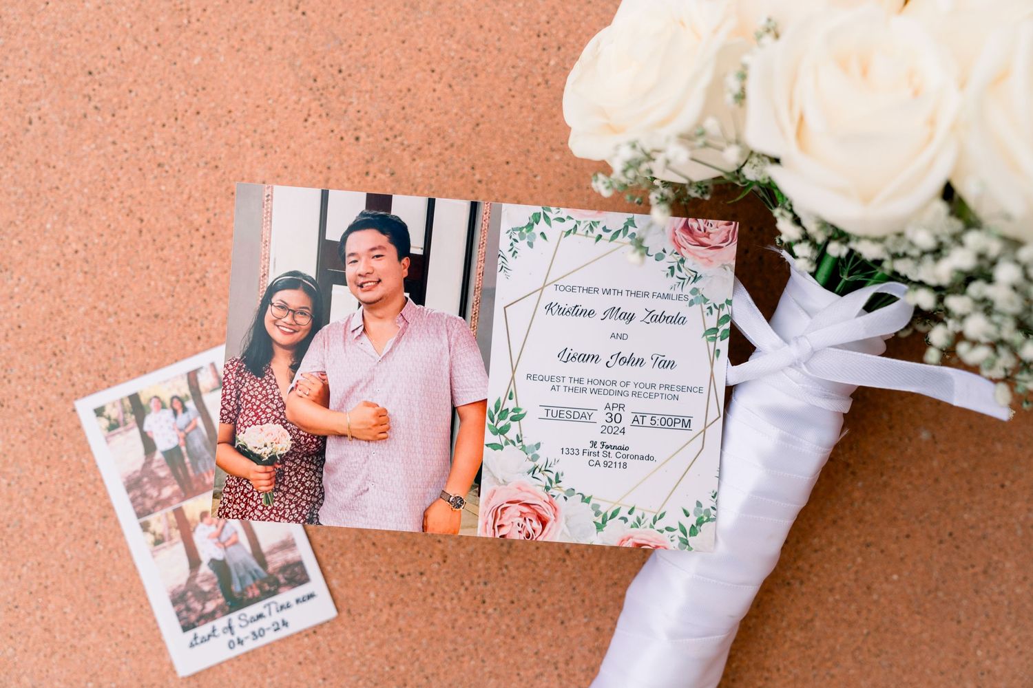 Wedding invitation and photos displayed with white roses and floral details.