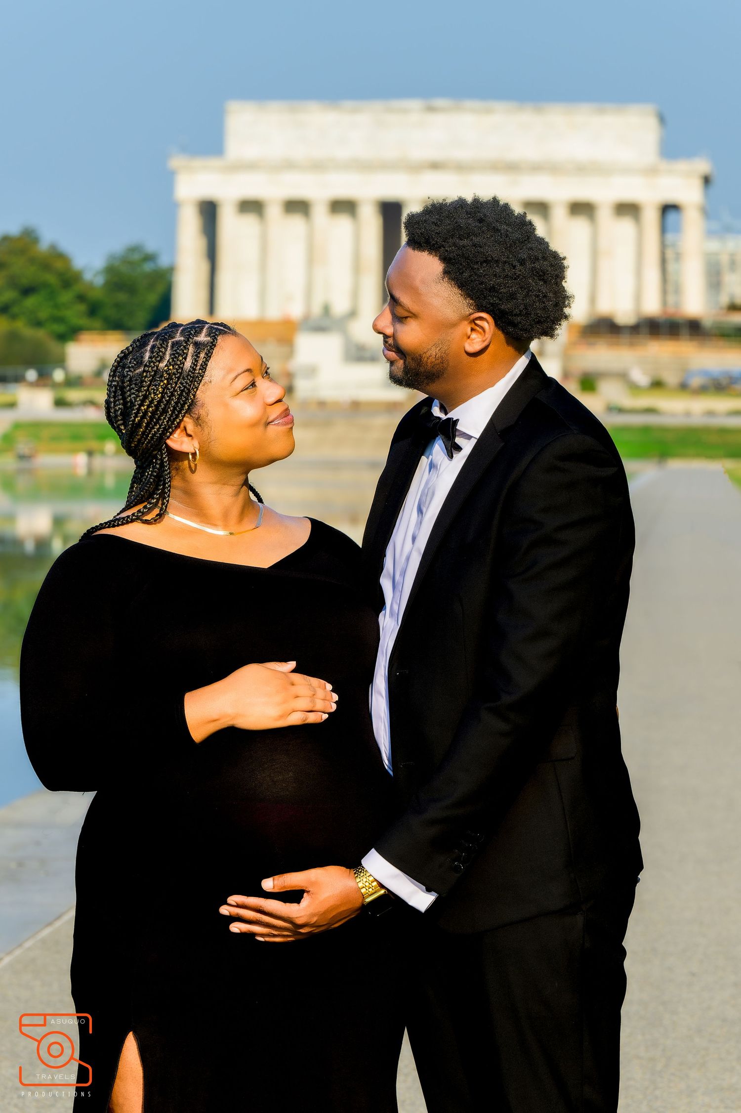 A couple shares a loving moment in formal attire with the Lincoln Memorial visible in the background.