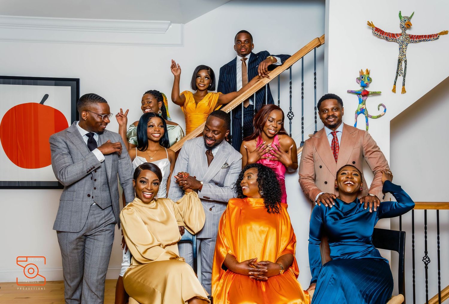 Group celebration photo with people in formal attire raising arms joyfully indoors.