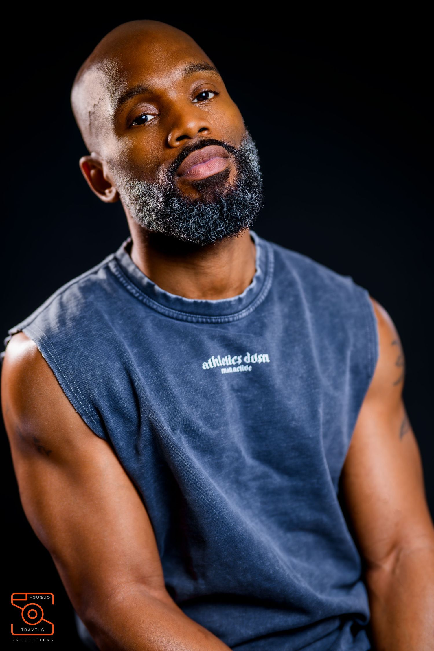 Studio portraits featuring person in sleeveless navy shirt against dark background.