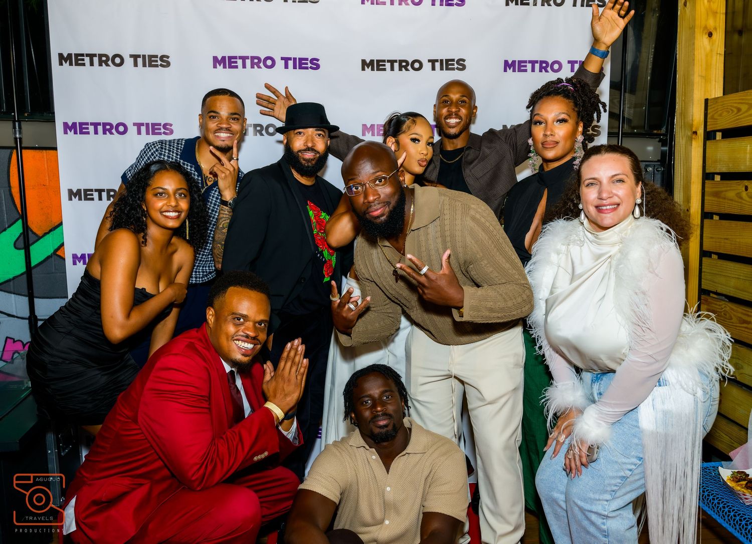 Group of friends posing together at a Metro Tire sponsored event with purple banners in the background.