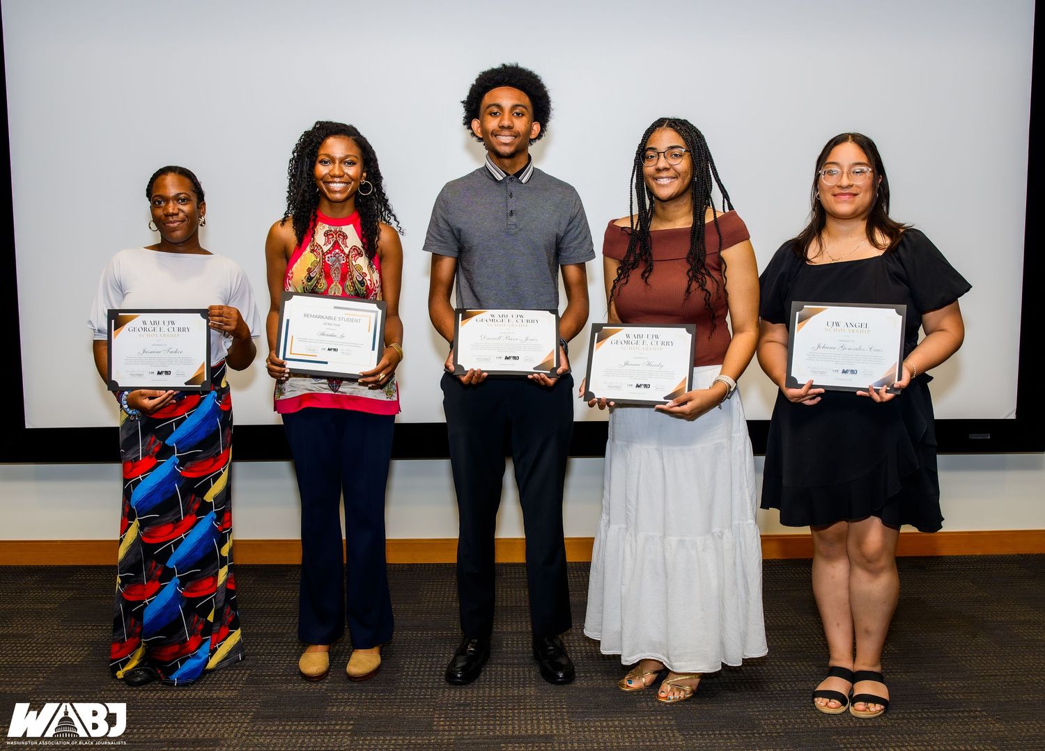 Students hold certificates and pose for graduation photos in formal attire during a celebratory ceremony.