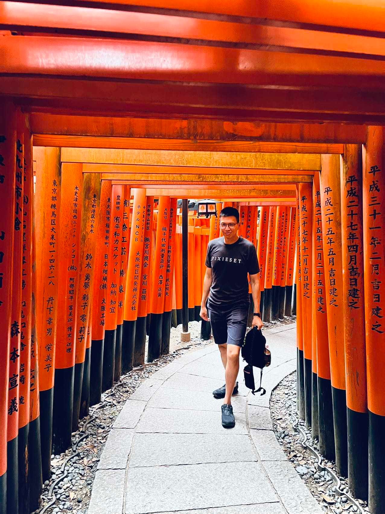 A path through the iconic orange torii gates at Fushimi Inari Shrine in Kyoto creates a vibrant tunnel effect.