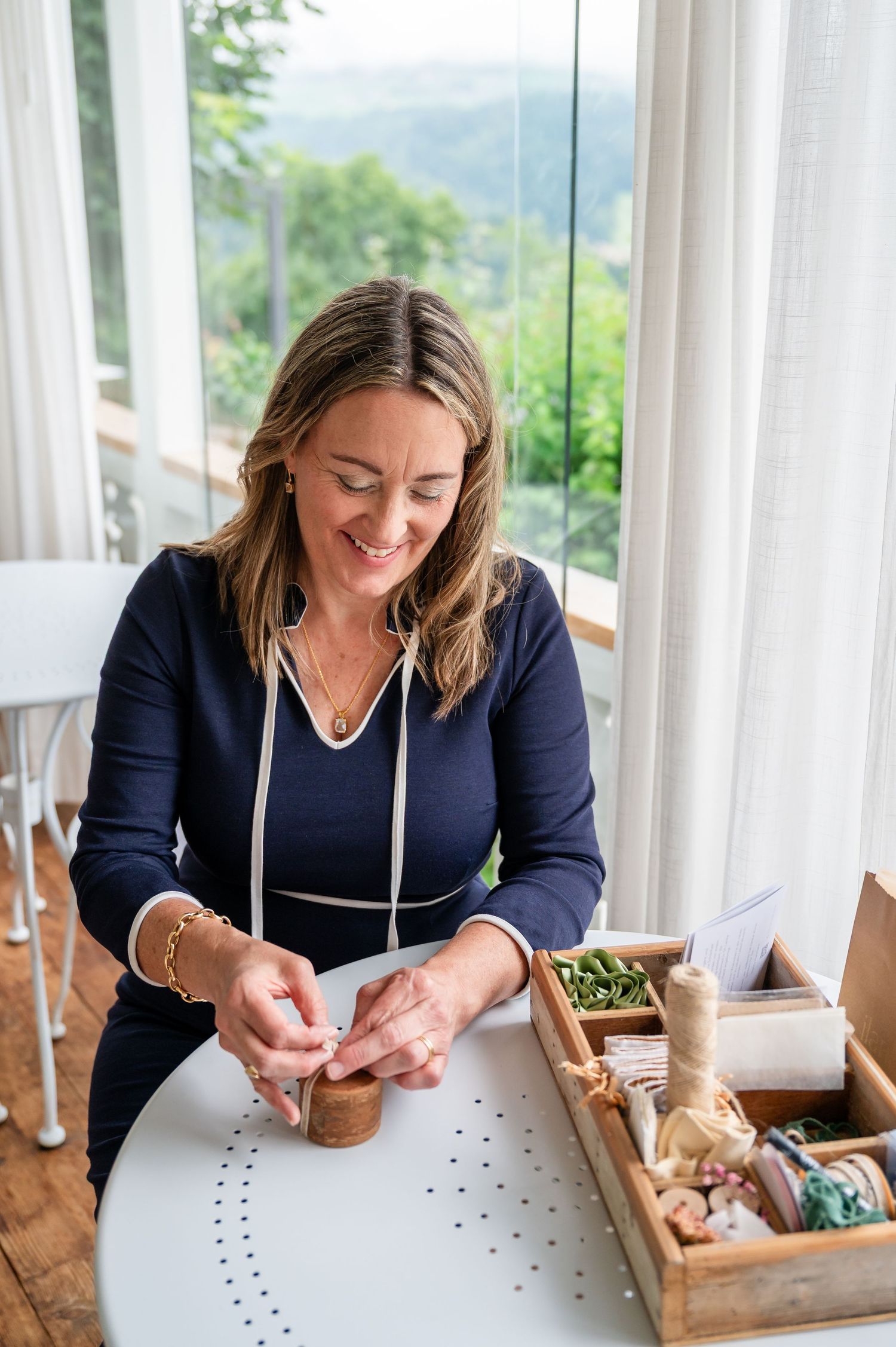 Frau verpackt handgemachten Schmuck am hellen Tisch – authentisches Bild für ein Herzensbusiness bei Thun