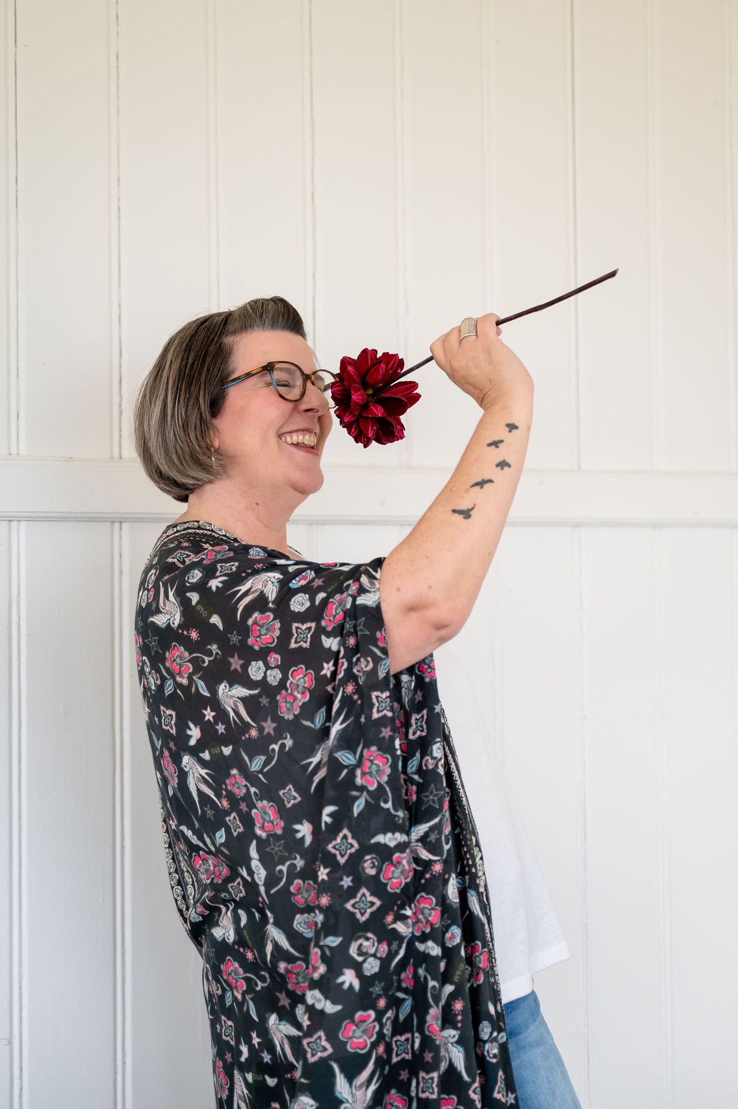 Lebensfrohes Portrait einer Coachin mit roter Blume – fotografiert im Raum Thun