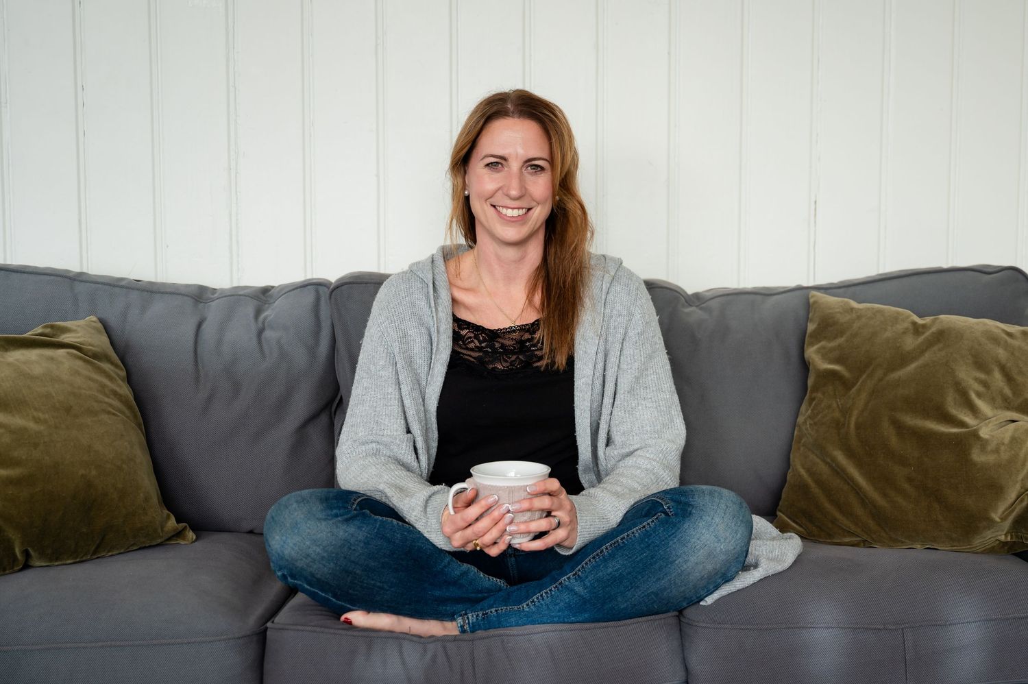 Selbstliebe-Portrait einer Frau in gemütlicher Kleidung – natürliches Indoor-Shooting auf dem Sofa