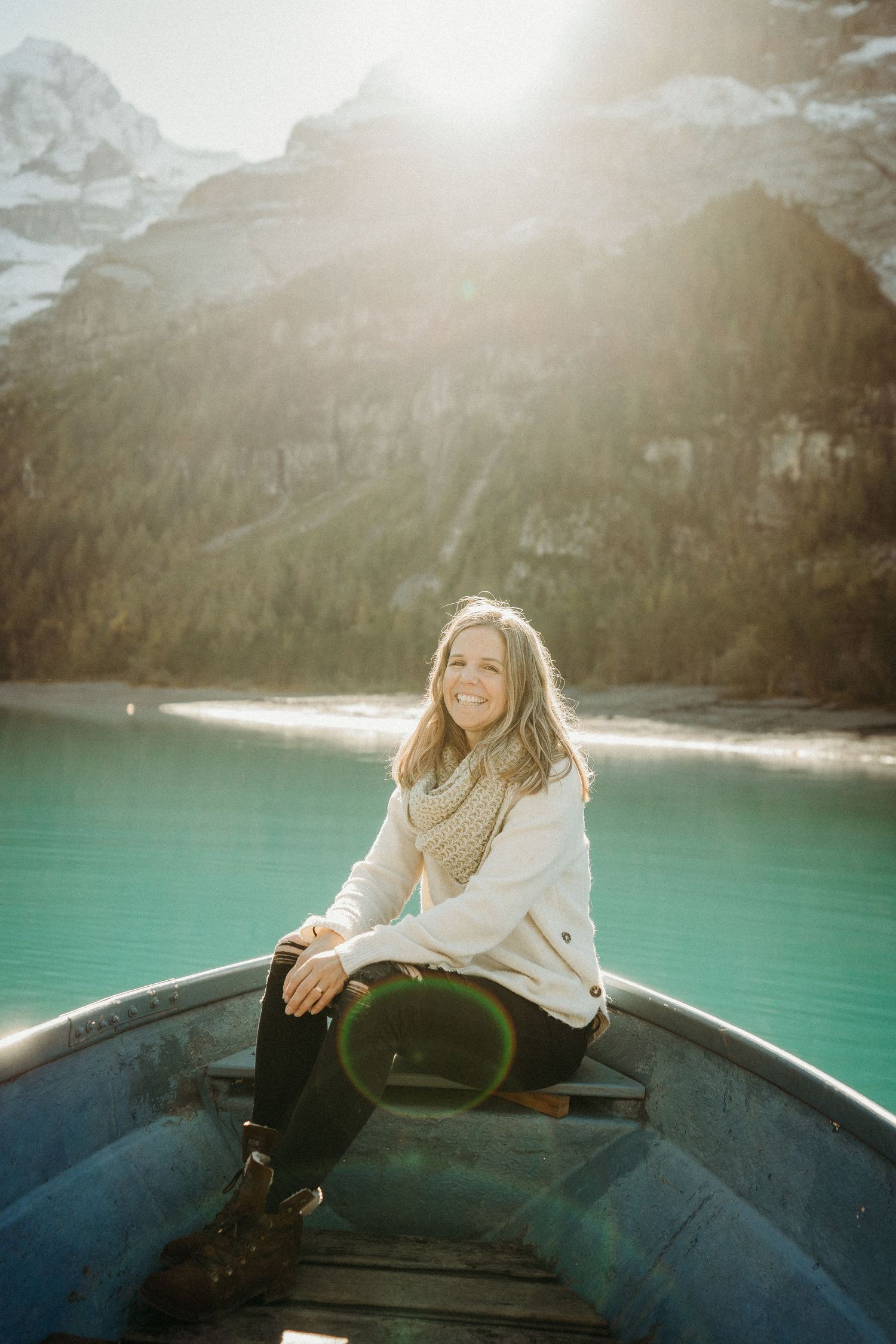 Frauen-Fotografin auf einem Boot am Oeschinensee im Morgenlicht