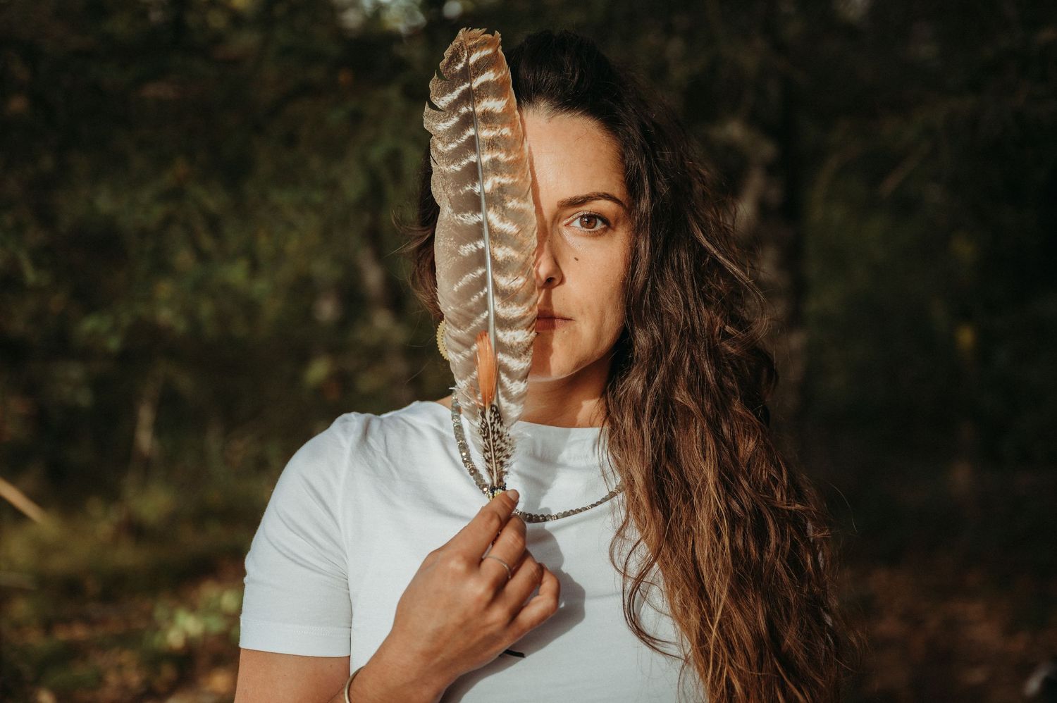 Kinesiologin oder Coachin mit Feder im Wald – Portrait mit Fokus auf Naturverbundenheit und energetische Tiefe
