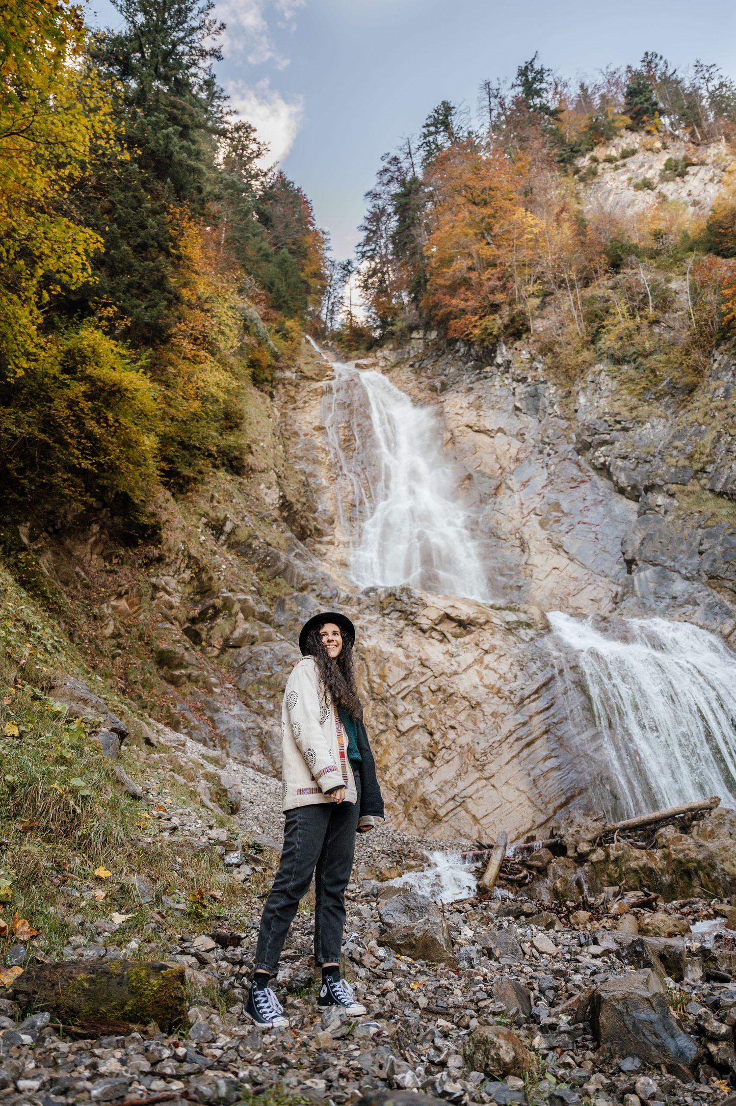 Frau vor dem Wasserfall bei Thun – herbstliches Outdoor-Portrait in wilder Naturkulisse mit warmen Farben und kraftvoller Stimmung.