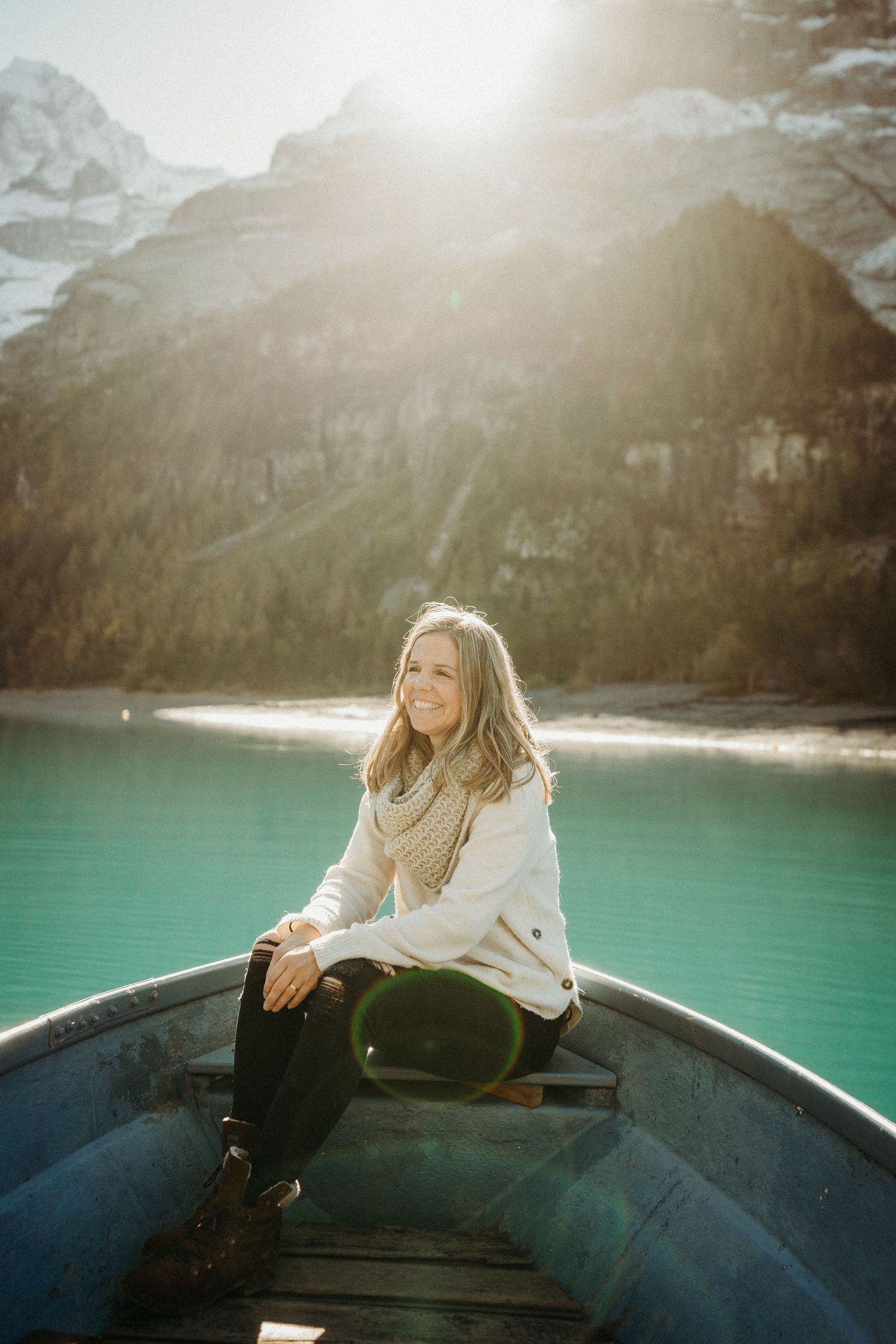 Frauen-Fotografin auf einem Boot am Oeschinensee im Morgenlicht