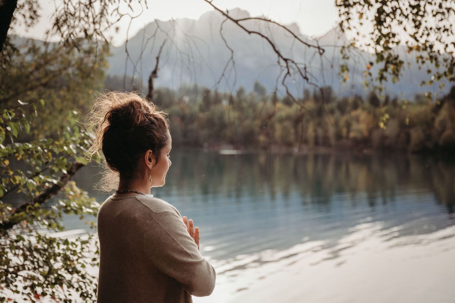 Kinesiologin steht am See und blickt auf die Berge – Businessfoto für ganzheitliche Arbeit mit Fokus auf Ruhe und Verbindung