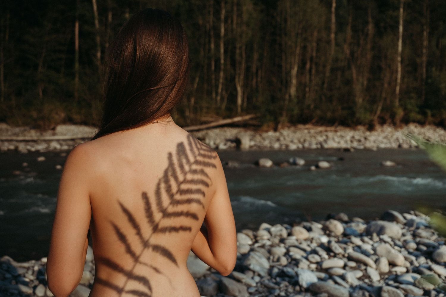 Natürliche Boudoirfotografie am Fluss bei Thun – sanftes Licht, Schatten, Weiblichkeit und Selbstliebe in wilder Umgebung.