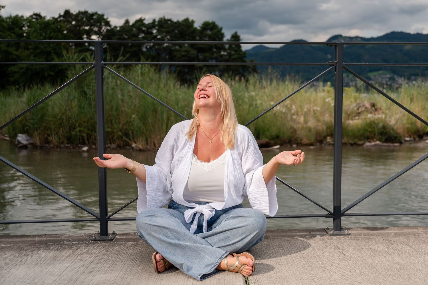 Lachende Frau mit ausgebreiteten Armen, mitten im Moment – Businessportrait draussen bei Thun