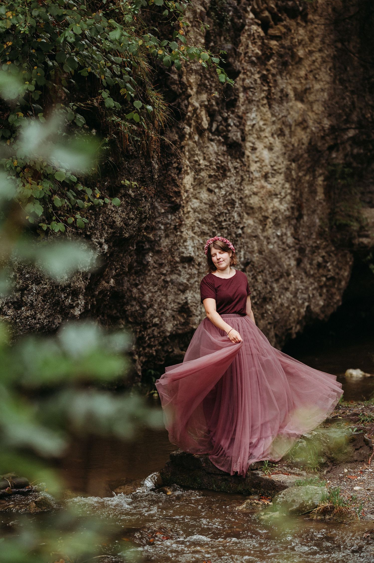 Frau mit Blumenkranz und Tüllrock steht am Bach im Strättligen Wald – märchenhaftes Portrait-Shooting in natürlicher Umgebung.