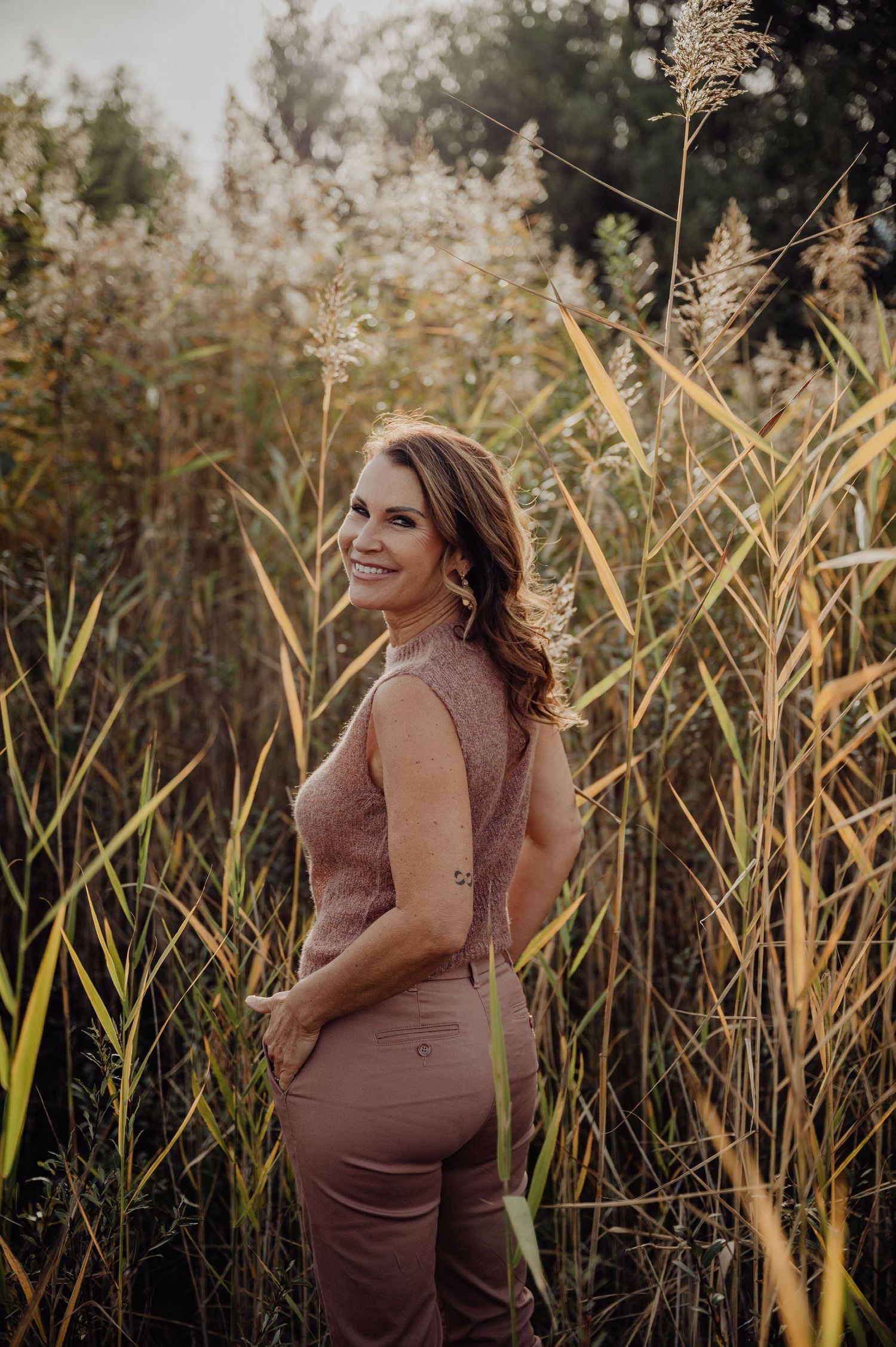 Authentisches Businessportrait einer Coachin in rosa Kleidung – Outdoor-Shooting inmitten von Natur und Herbstfarben