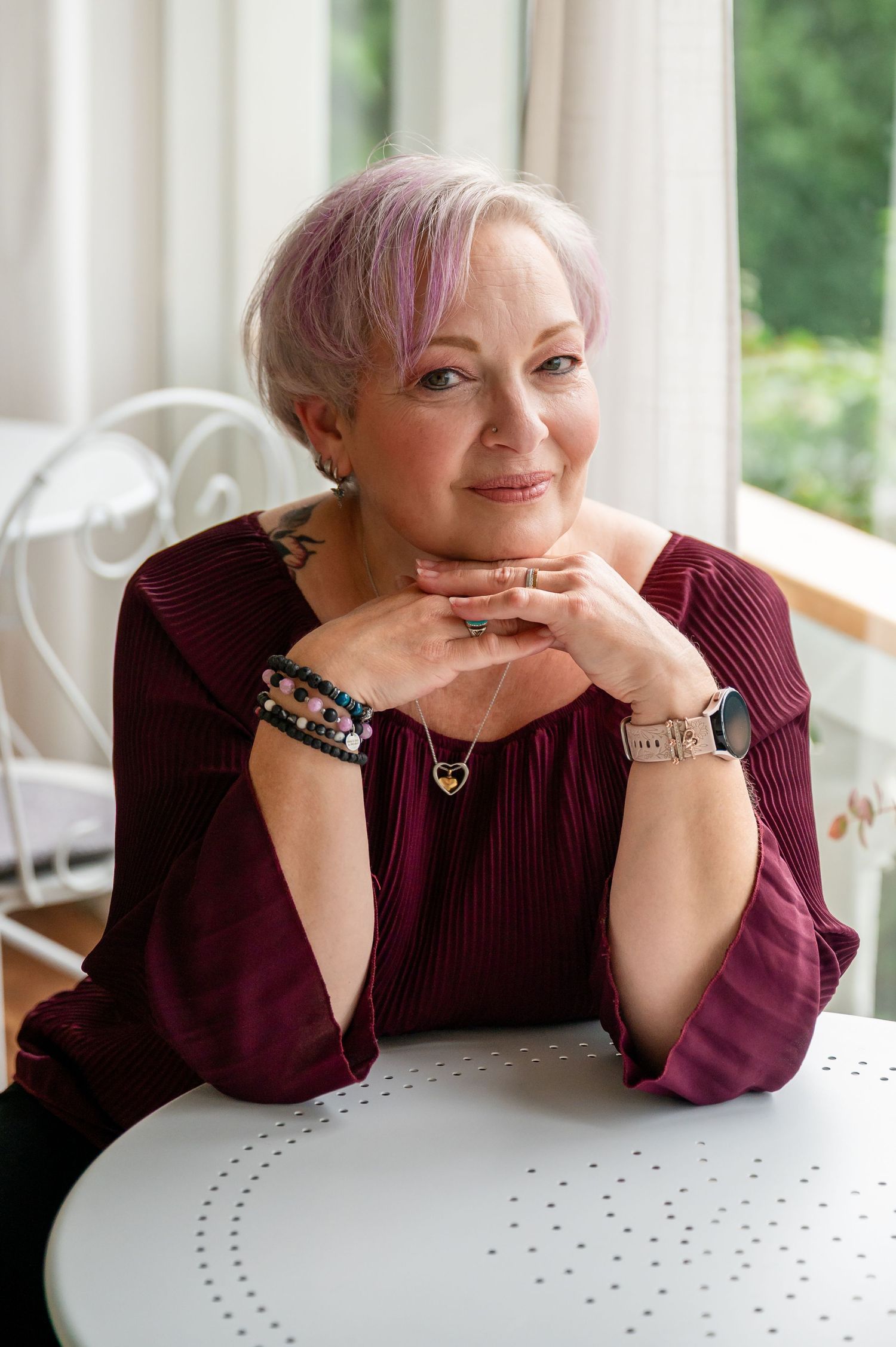 Selbstliebe-Shooting in Thun: authentisches Portrait einer Frau 50plus mit lila Haaren, die selbstbewusst in die Kamera lächelt.