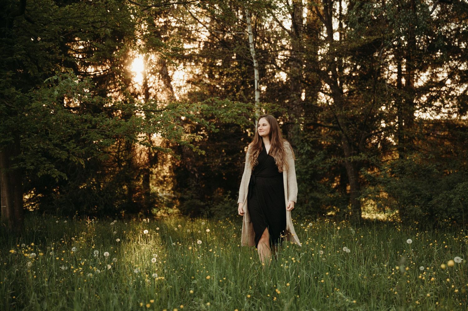 Lachende Frau in Wiese bei Sonnenuntergang – natürliches Portrait in warmem Licht, Frühlingsstimmung und Lebensfreude im Grünen.