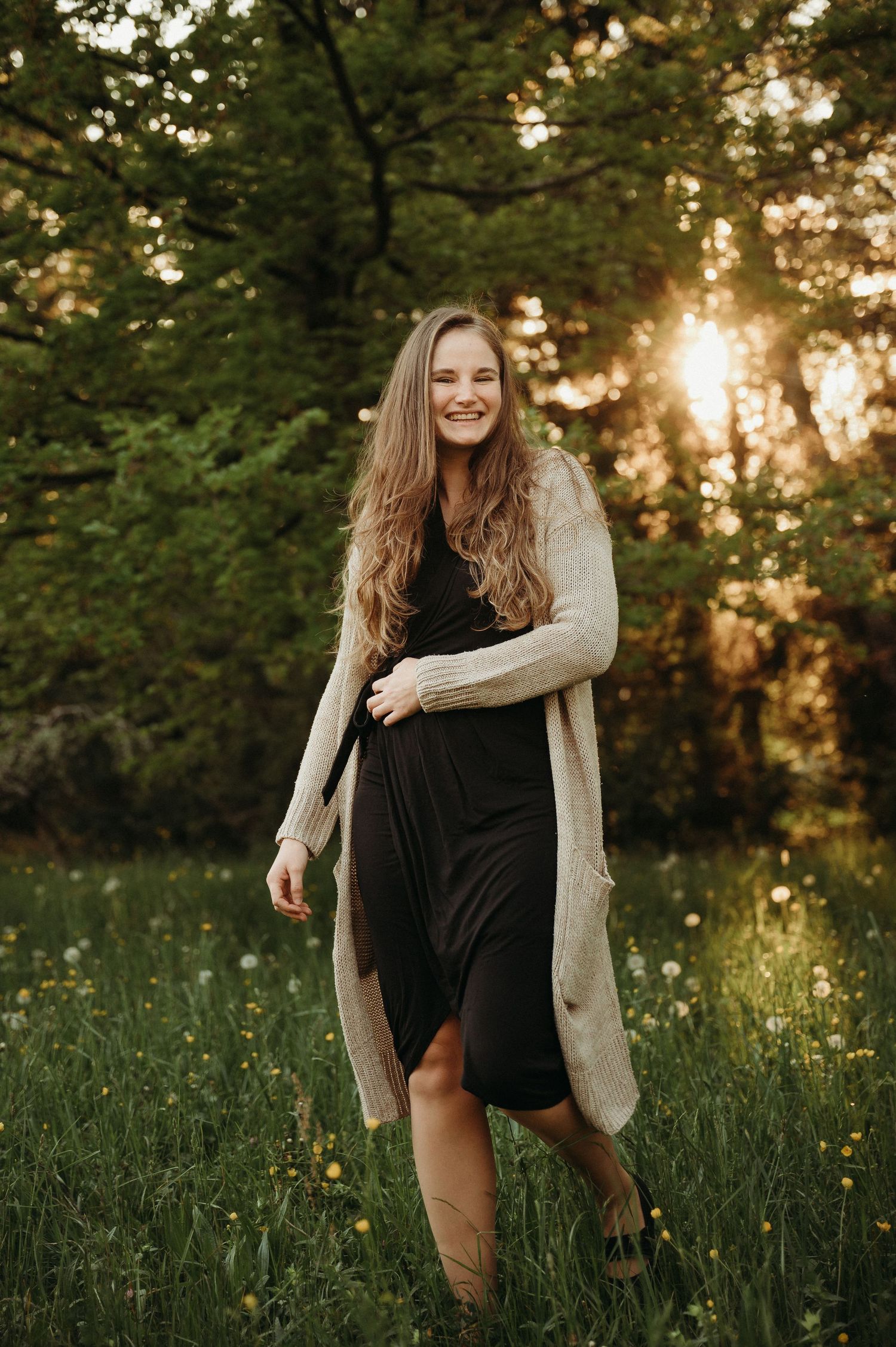 Lachende Frau in Wiese bei Sonnenuntergang – natürliches Portrait in warmem Licht, Frühlingsstimmung und Lebensfreude im Grünen.
