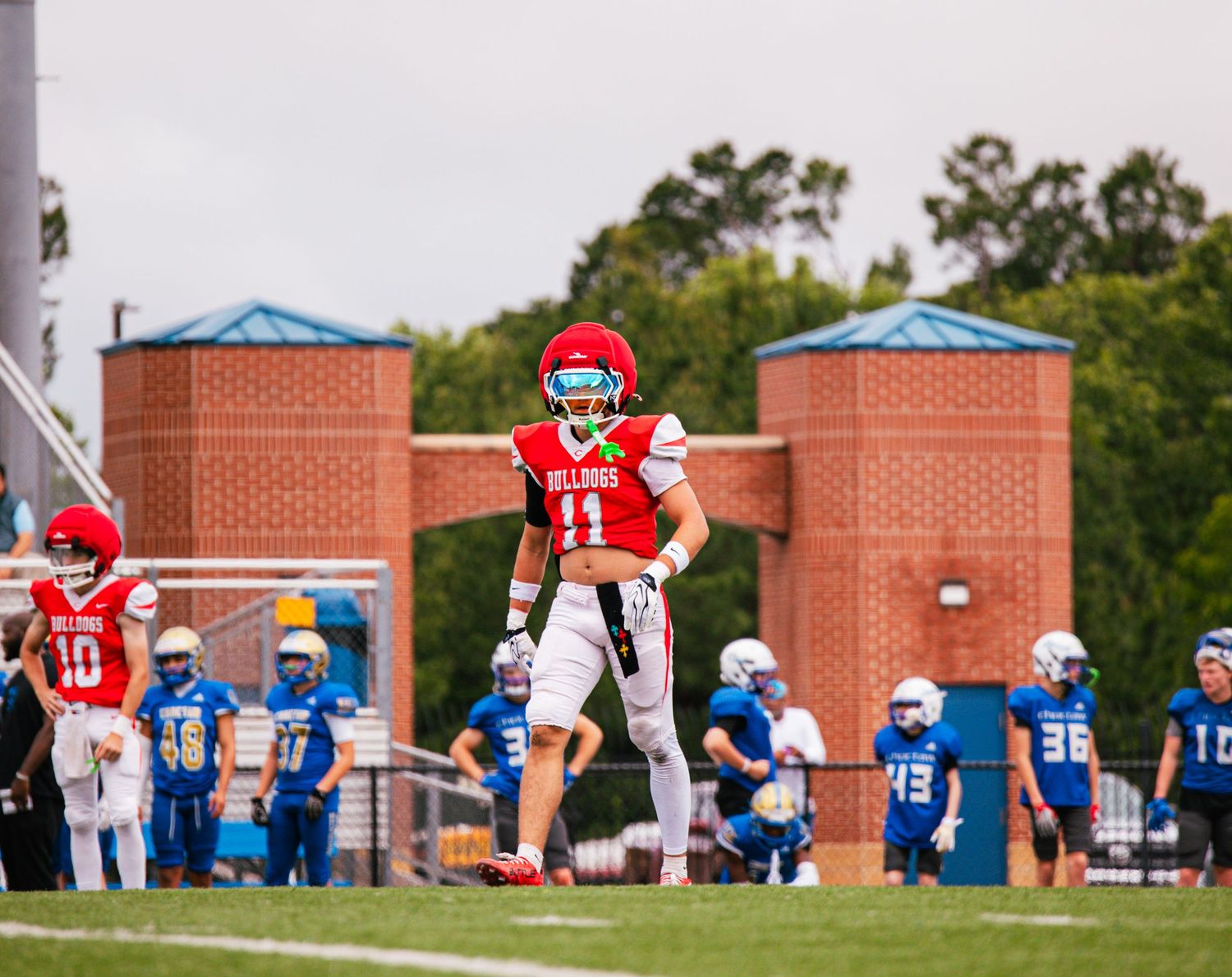 A Bulldogs football player wearing number 11 stands on the field during a game.