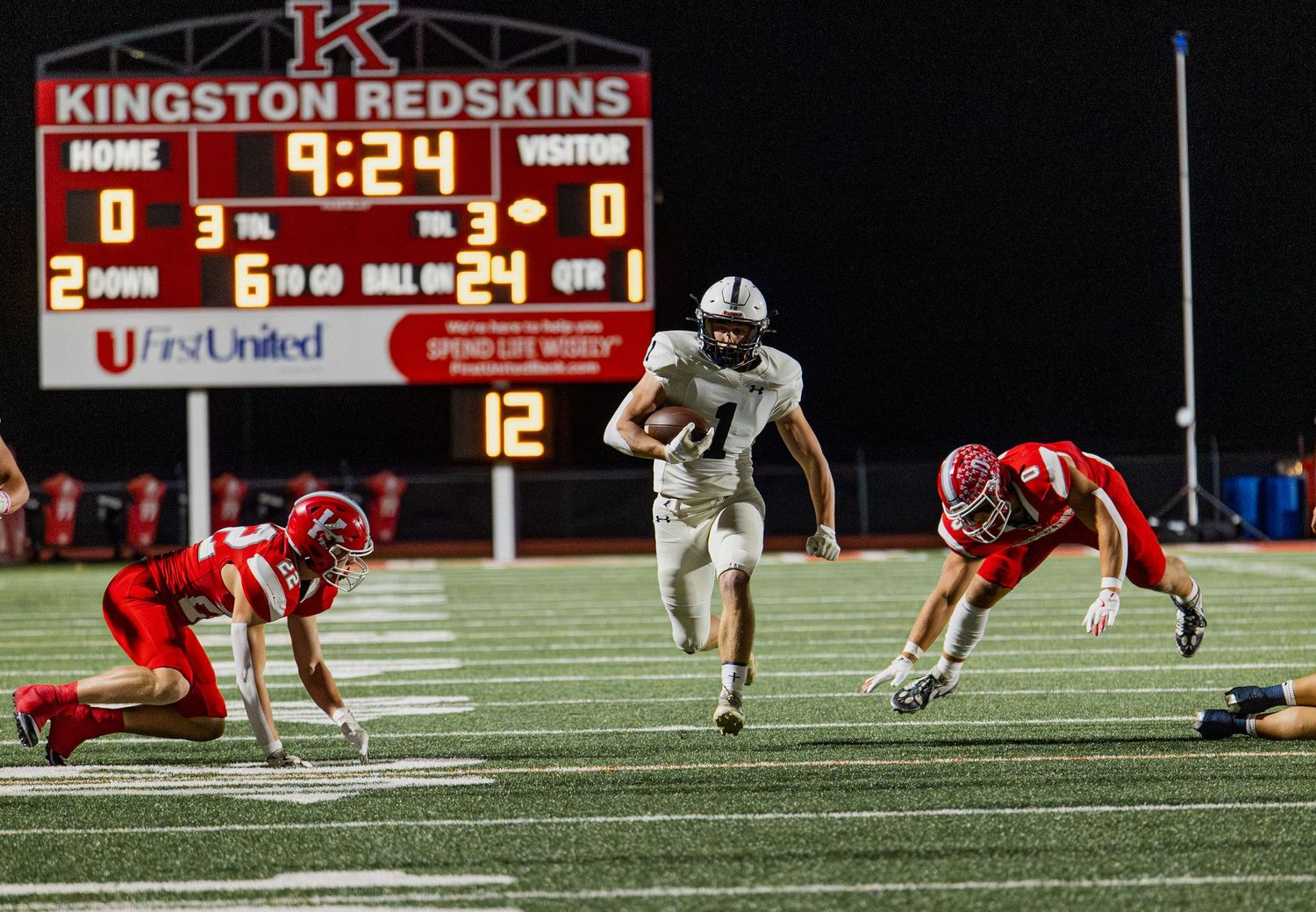 Football player #21 in white breaks free for a long run against Kingston Redskins defenders.