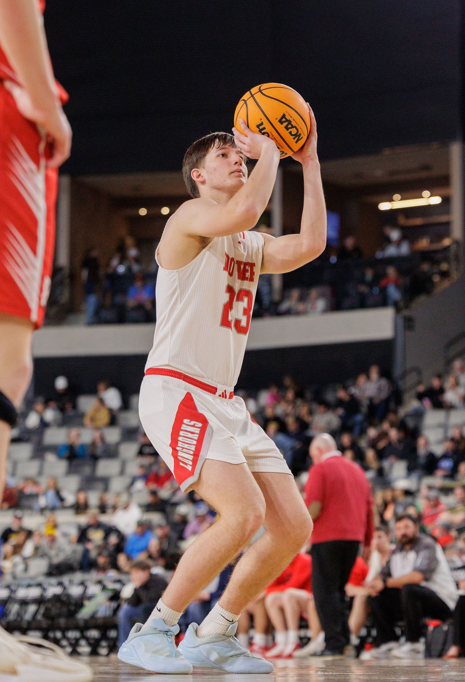 A basketball player wearing number 23 prepares to shoot during a competitive game.