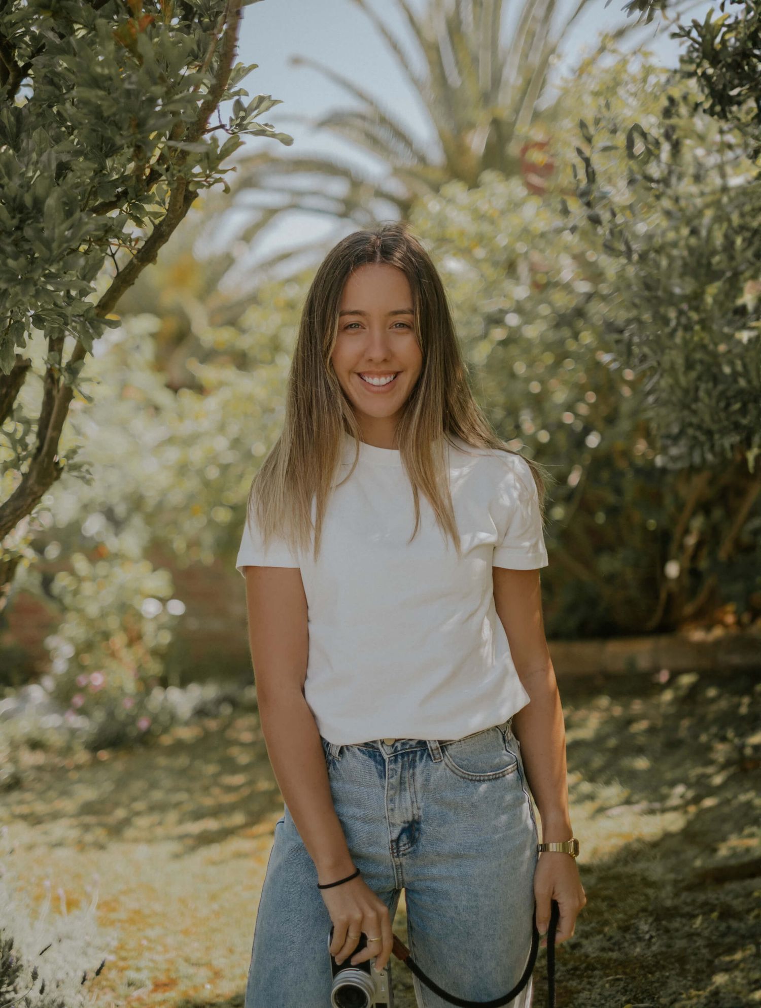 portrait of Samantha Panciera standing in garden setting with camera