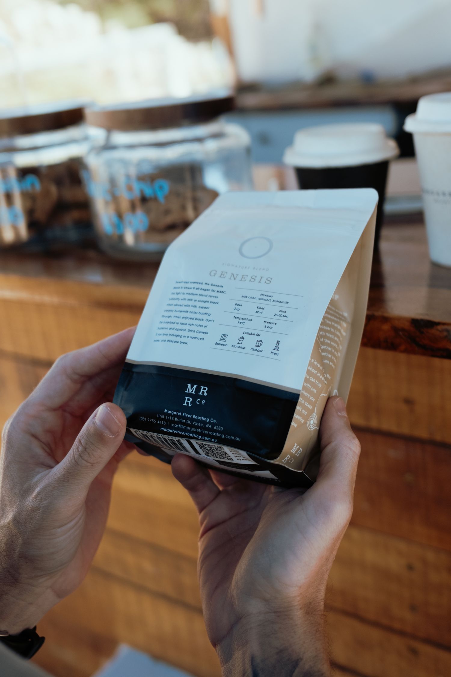 Hands holding Margaret River coffee co. packaging showing product details and branding.