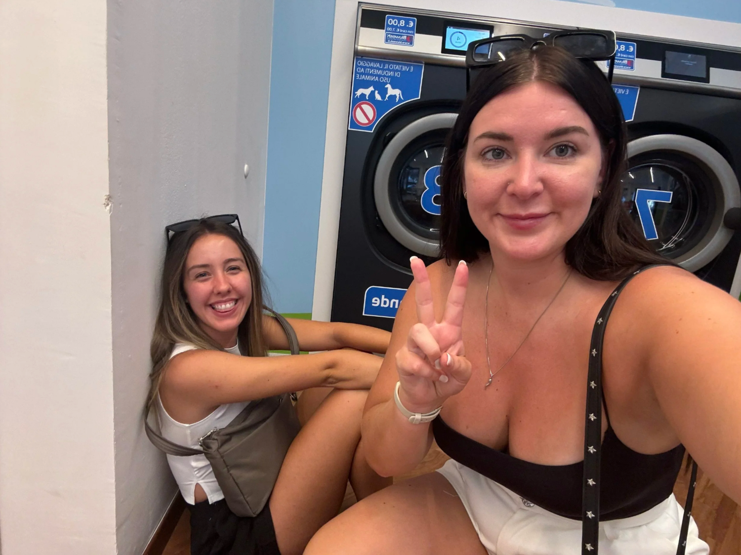 Group taking fun selfies at a laundromat with washing machines visible behind them.