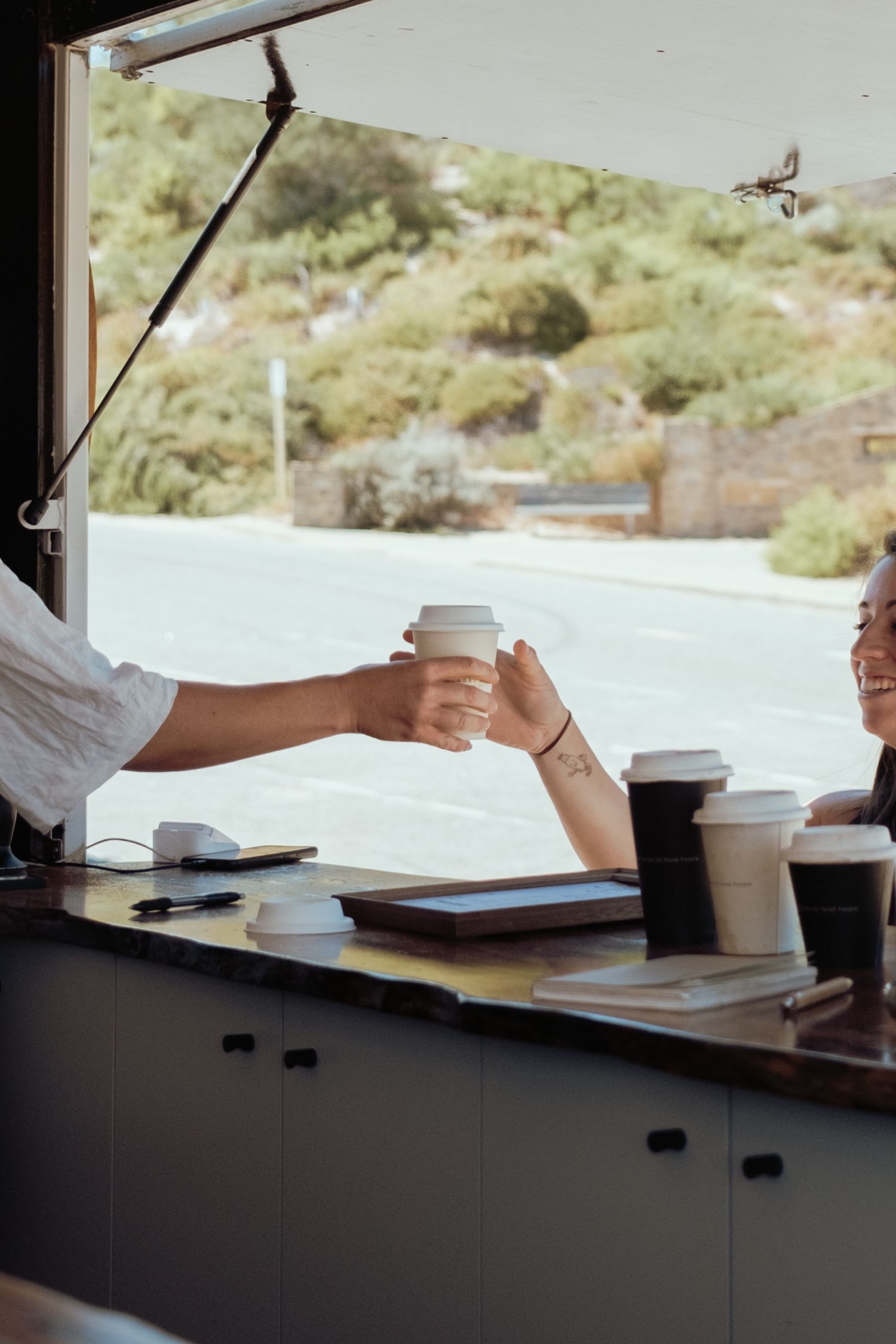Coffee cups arranged on a counter with scenic views through the window.
