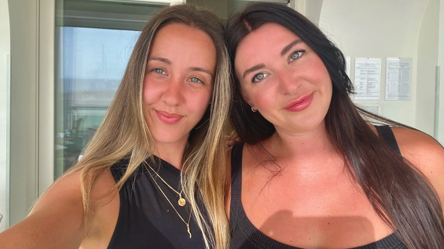 Two friends posing together for a casual indoor selfie.