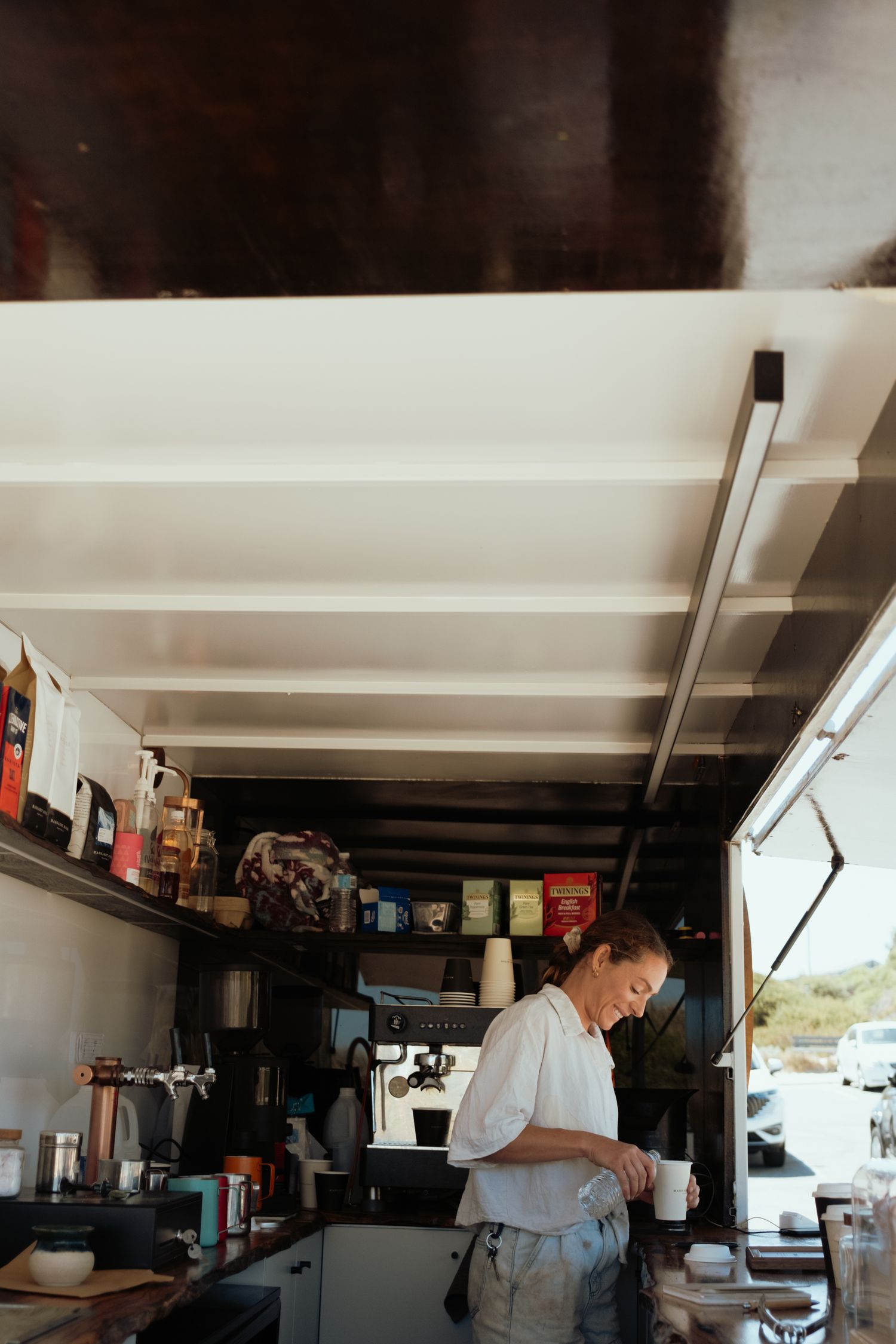 Interior view of a coffee shop with white ceiling beams and rustic decor.