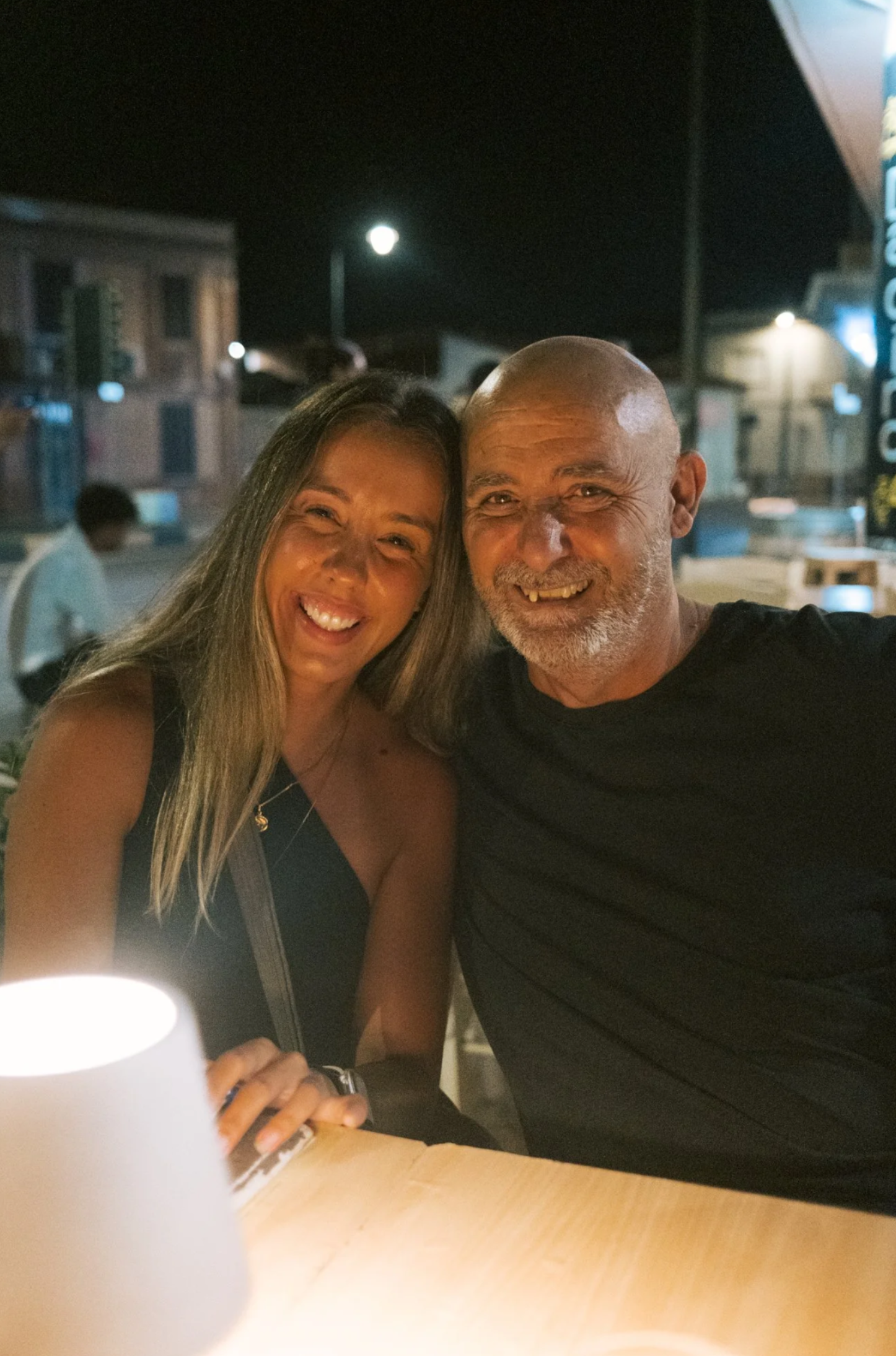 Nighttime photos of people smiling together under warm lighting.