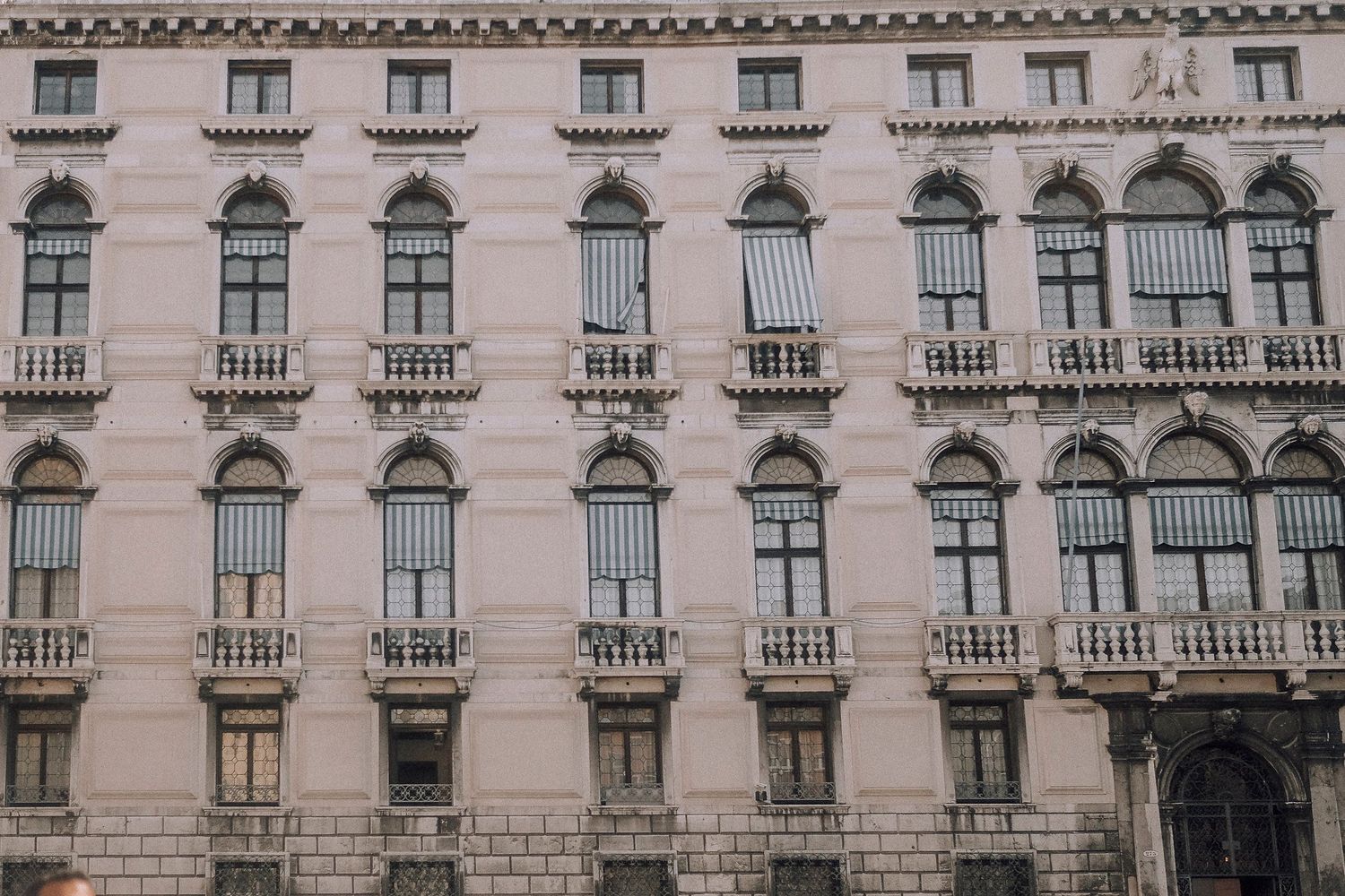 Grand historic building facade with ornate architectural details and repeating arched windows.