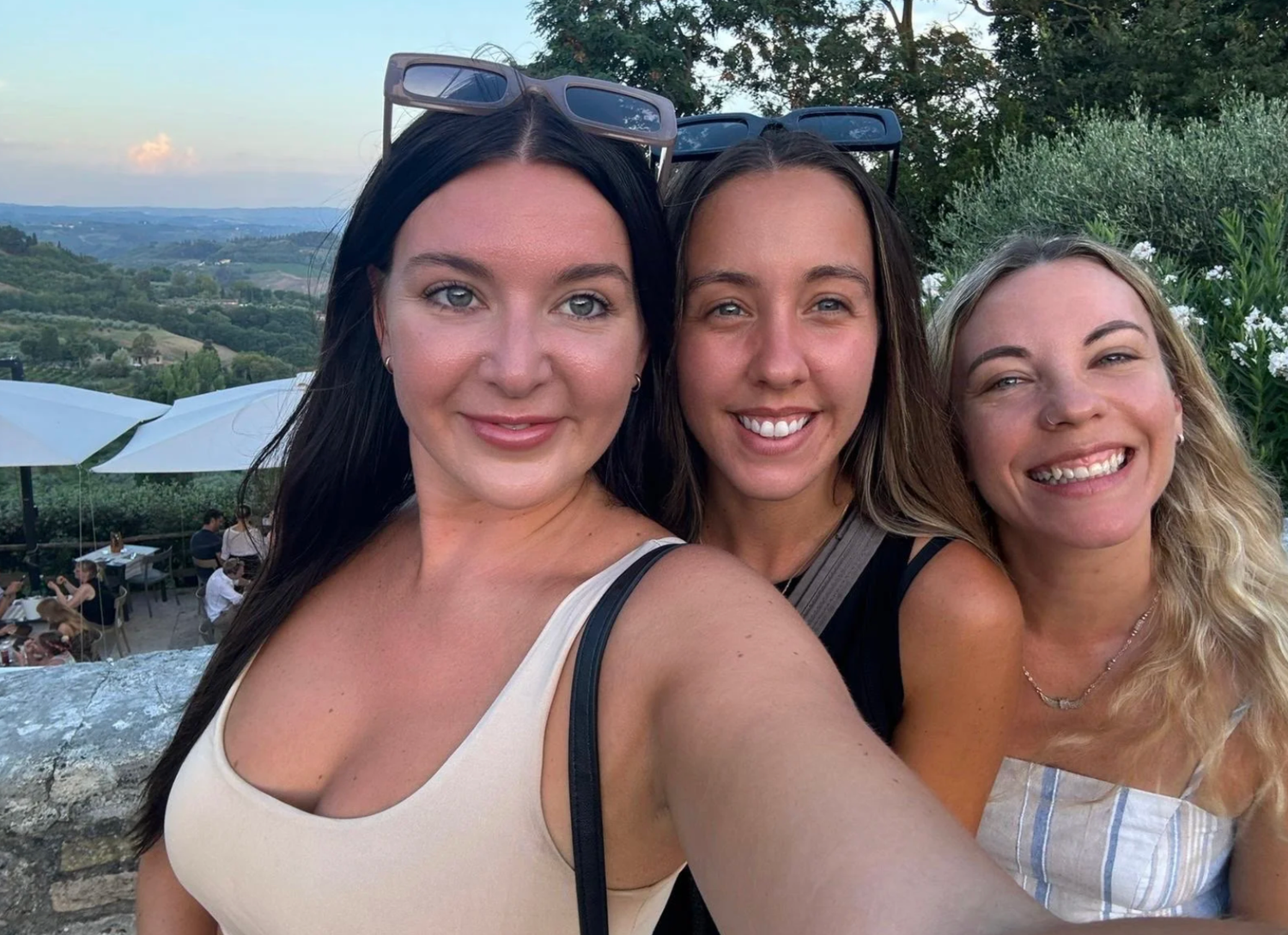 Group of friends taking selfies together against various scenic outdoor backgrounds.