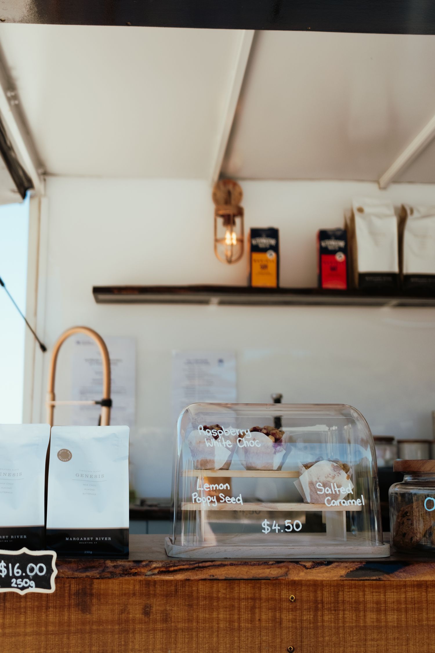 Wooden coffee bar counter with glass display cases and minimal decor.