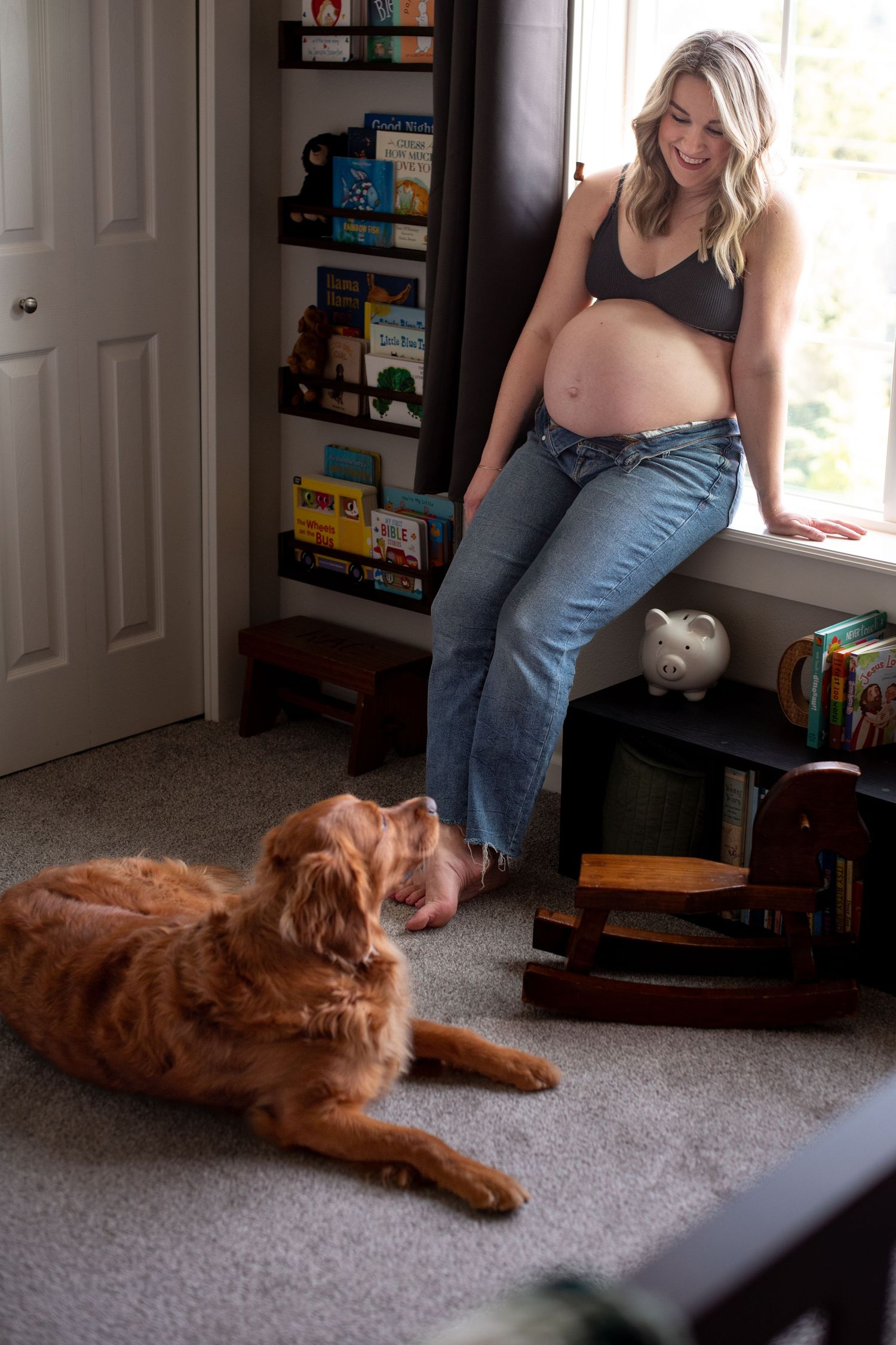 A golden retriever dog lies stretched out on gray carpet while someone stands nearby in a room with bookshelves. Located in Salem, OR