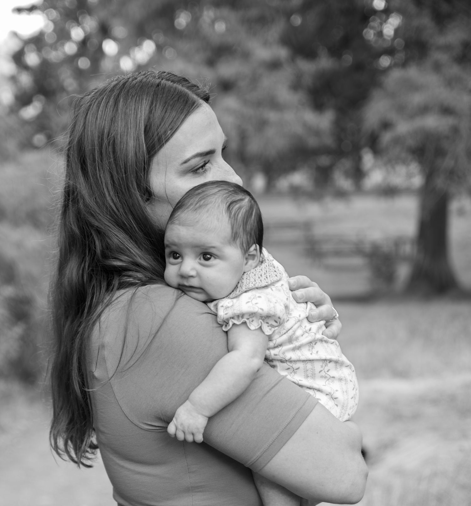 Mother embracing infant in black and white photo in a park located in Salem, OR.