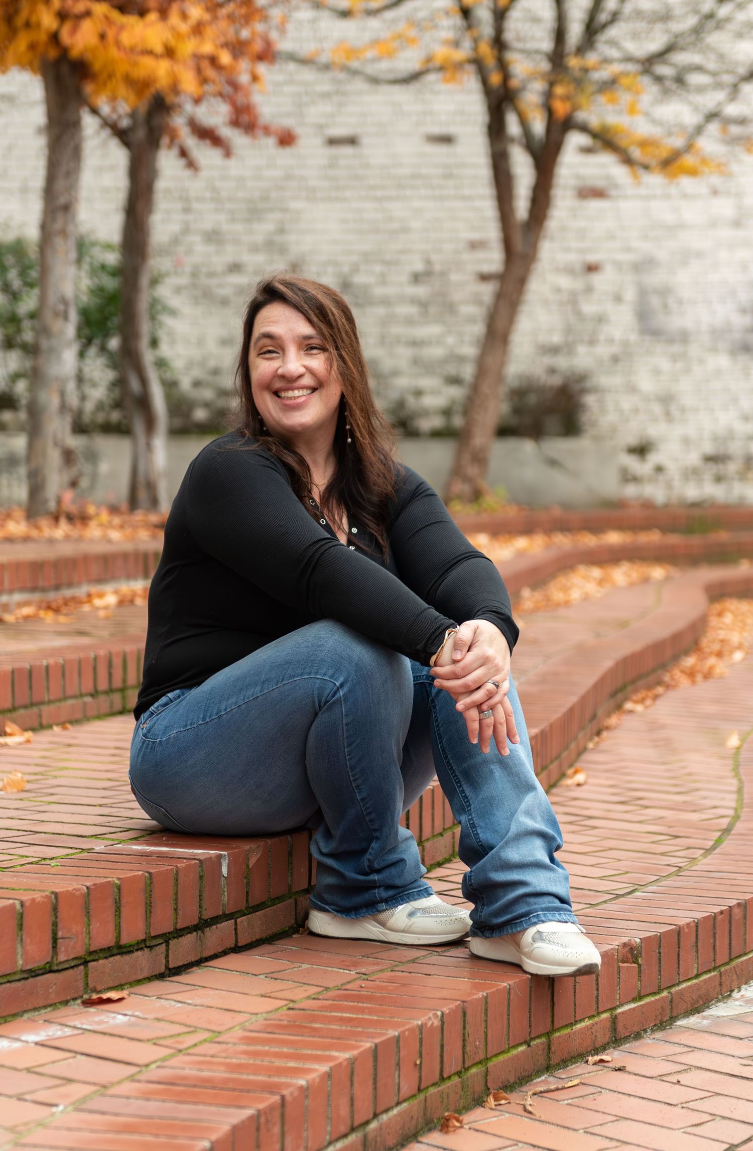 Headshot of woman on steps with red brick background, for branding images, located in Salem, OR.