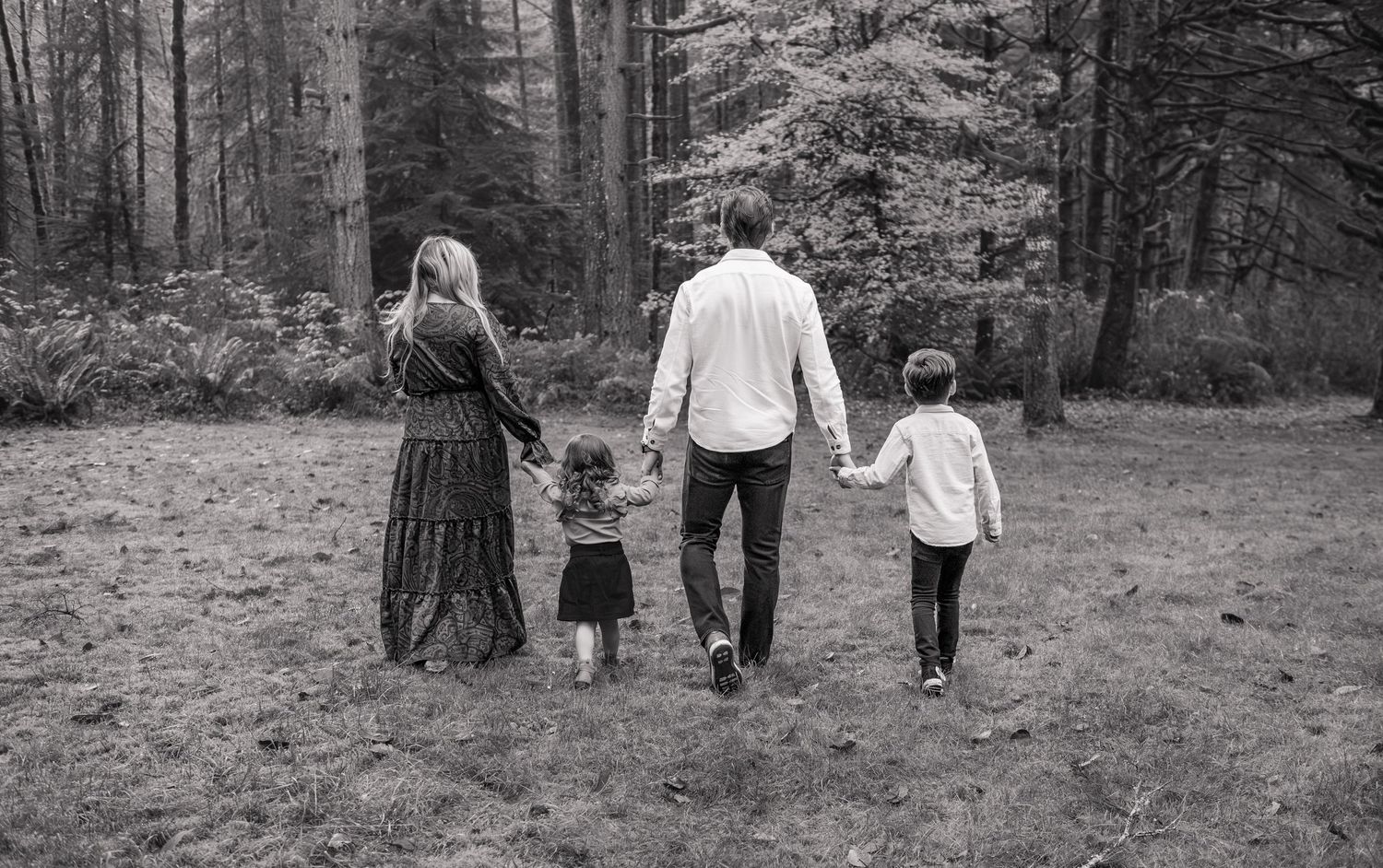 A series of black and white photos showing people walking together through a wooded forest area. Silverton, OR