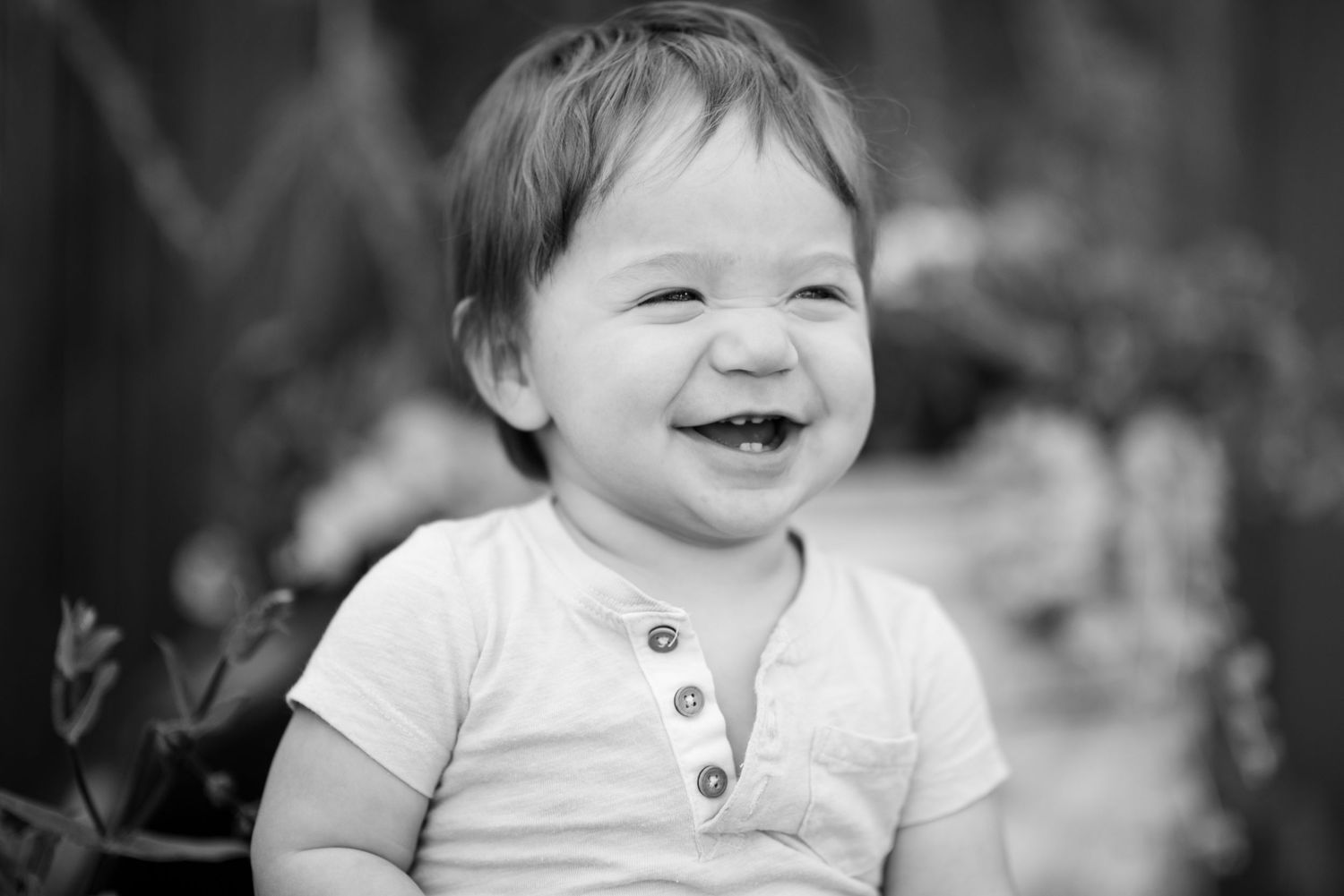 A series of black and white photos showing a baby's joyful expressions and infectious laughter.