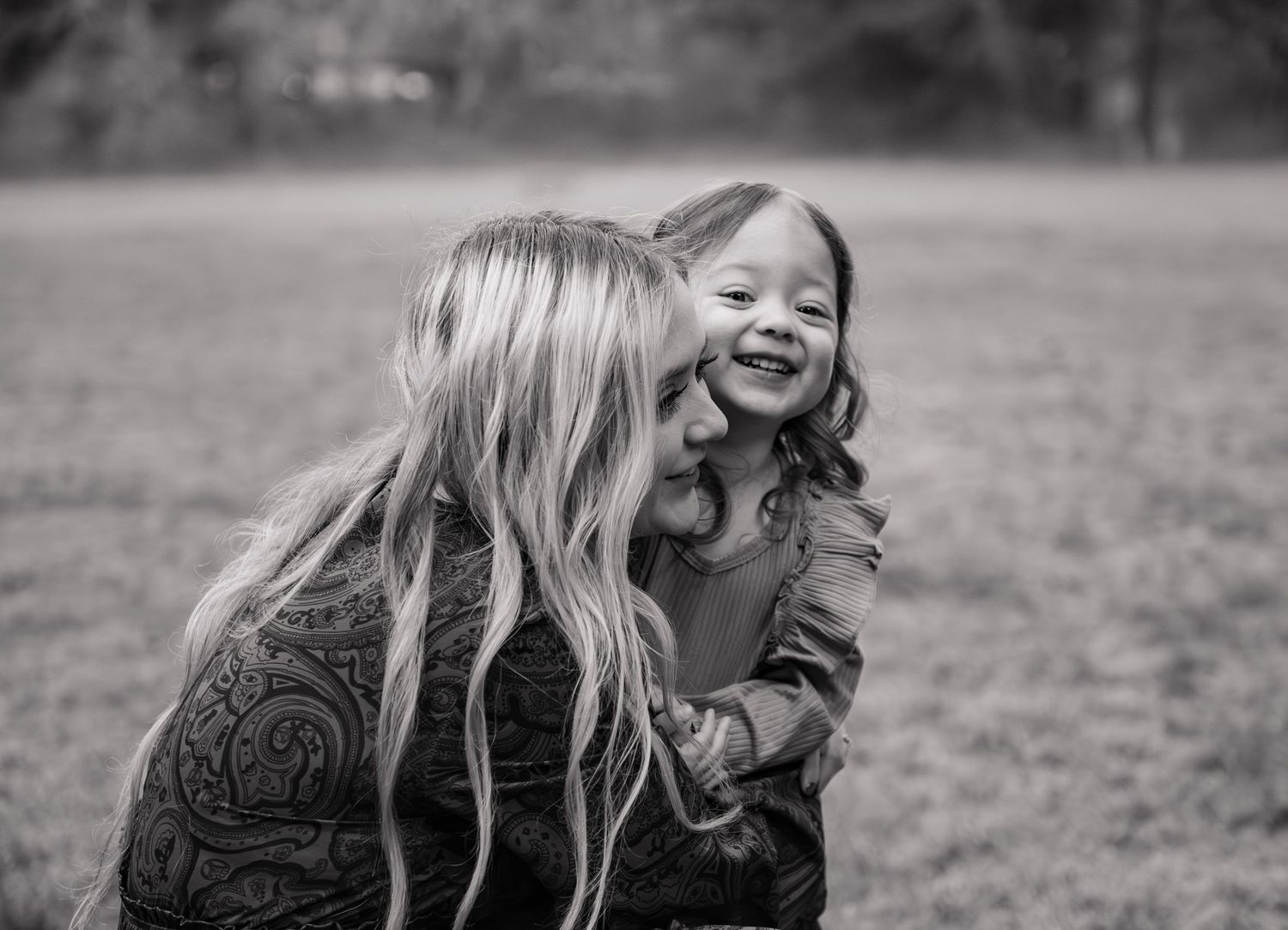 Black and white sequence showing two people playing and laughing together outdoors in a candid moment. Silverton, OR
